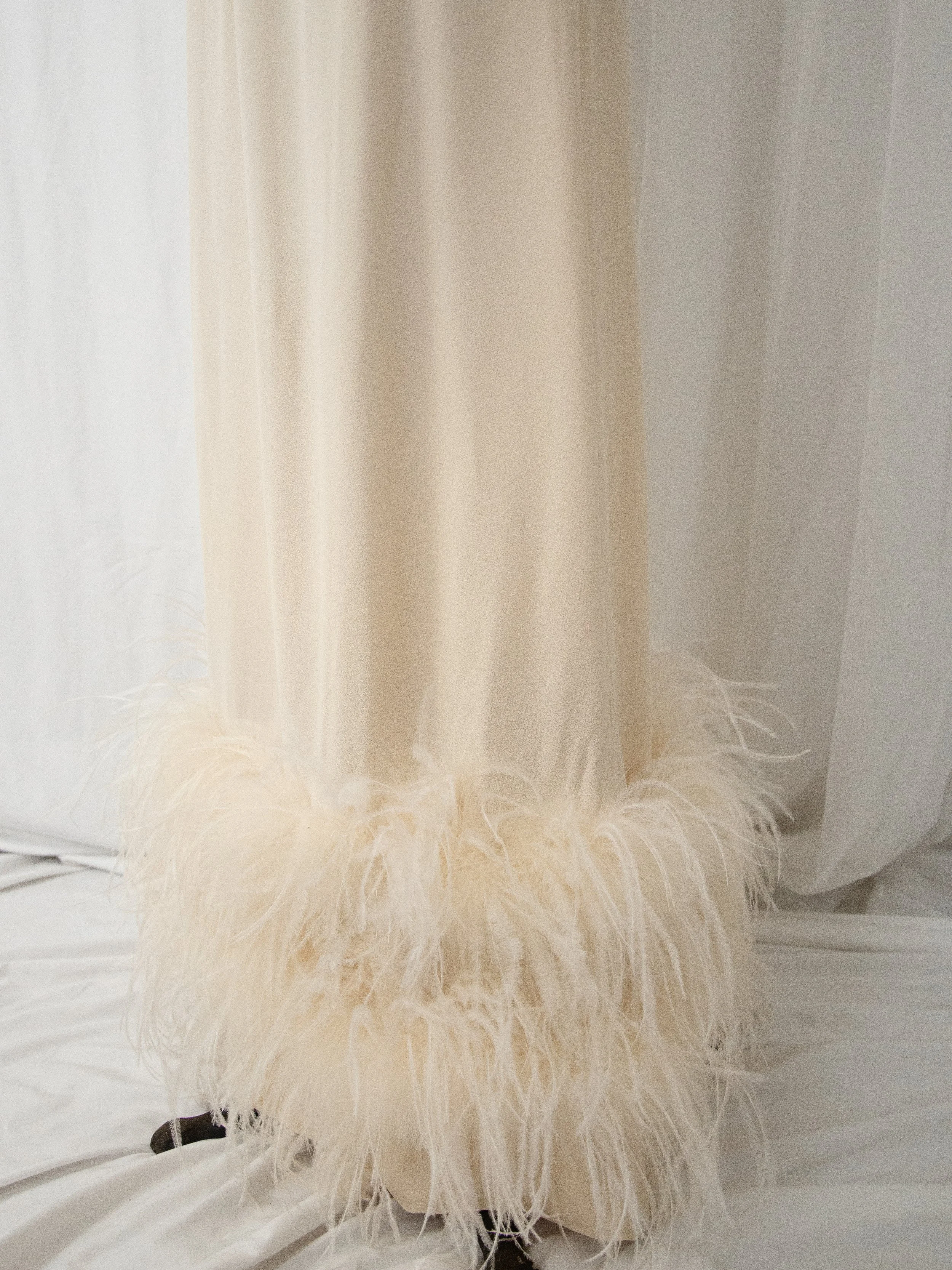 Detail of the late 1950s gown's hem trimmed with fluffy cream ostrich feathers.