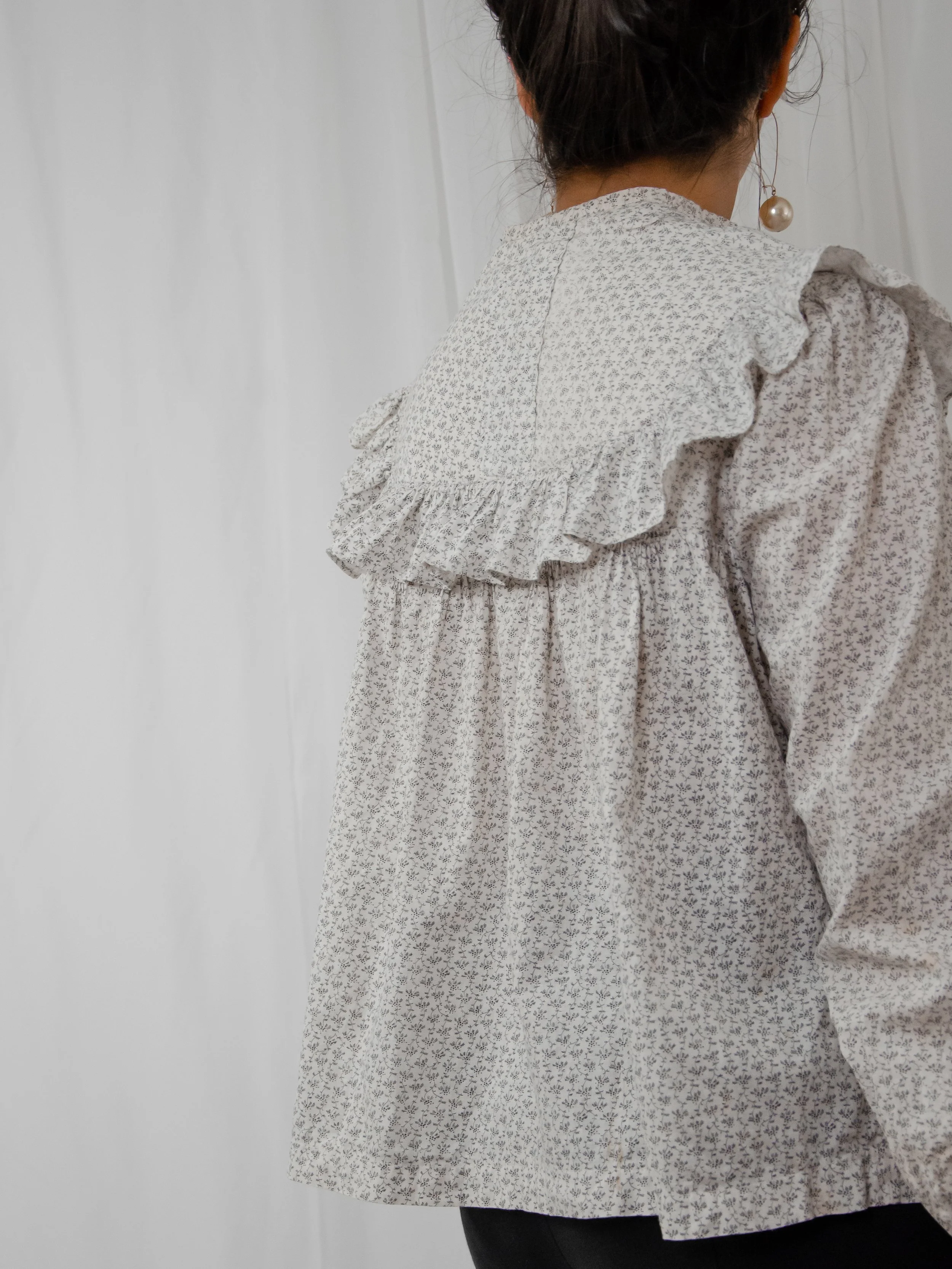 Back view of the 1890s Victorian calico top on a model, showing the ruffled yoke and gathered back.
