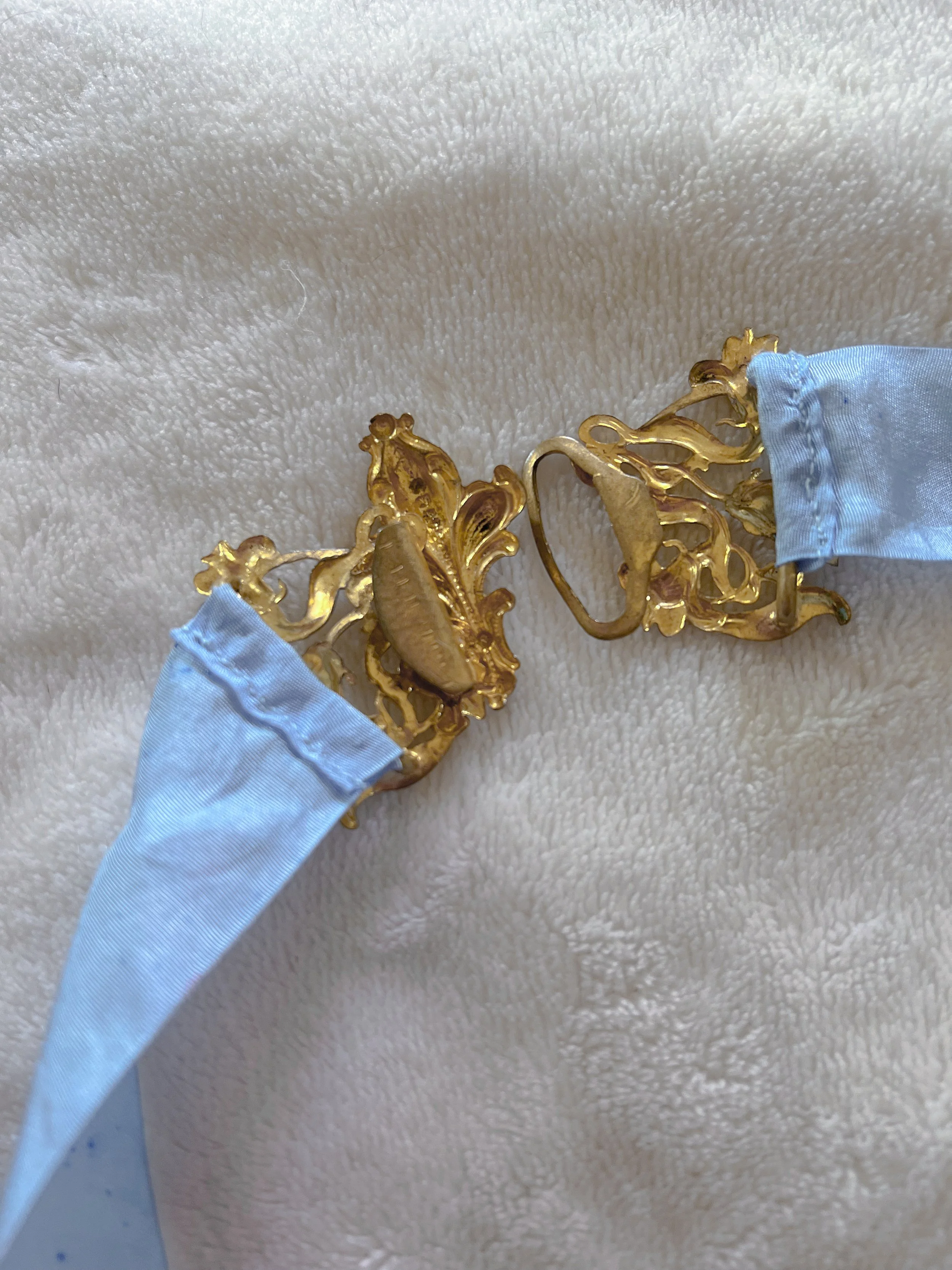 Detail of the 1930s art nouveau gold filigree buckle unfastened, showing the hook-and-loop closure halves.