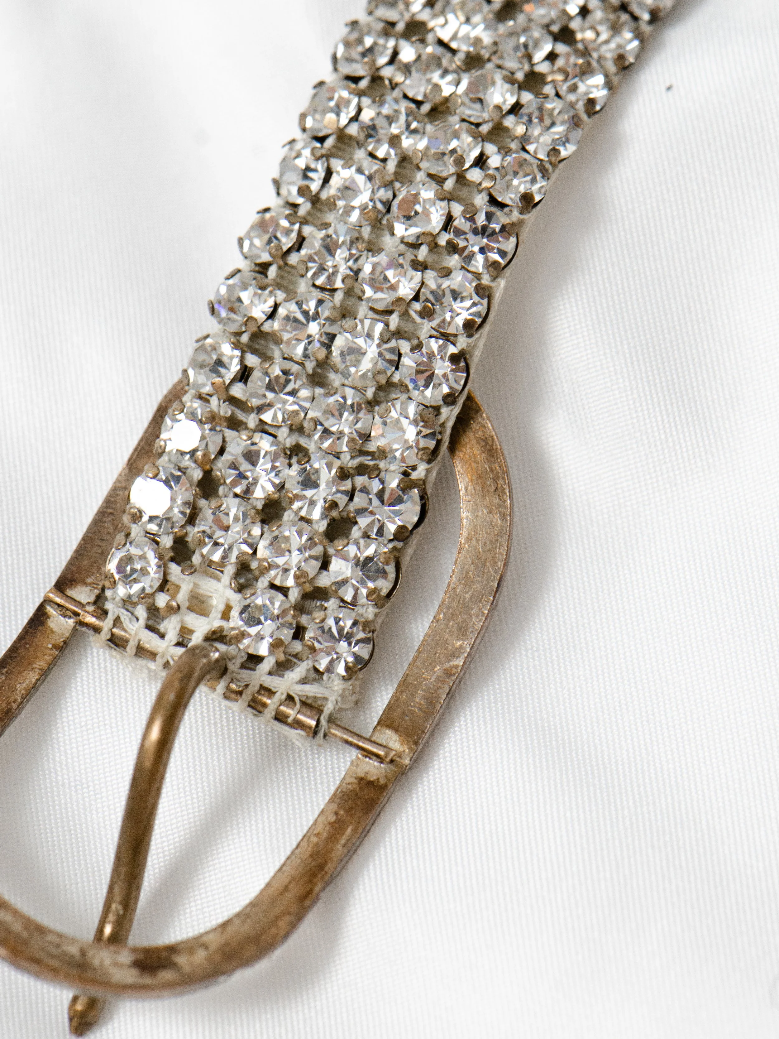 Detail of the back of the 1950s rhinestone belt buckle, showing wear on the silver plating.