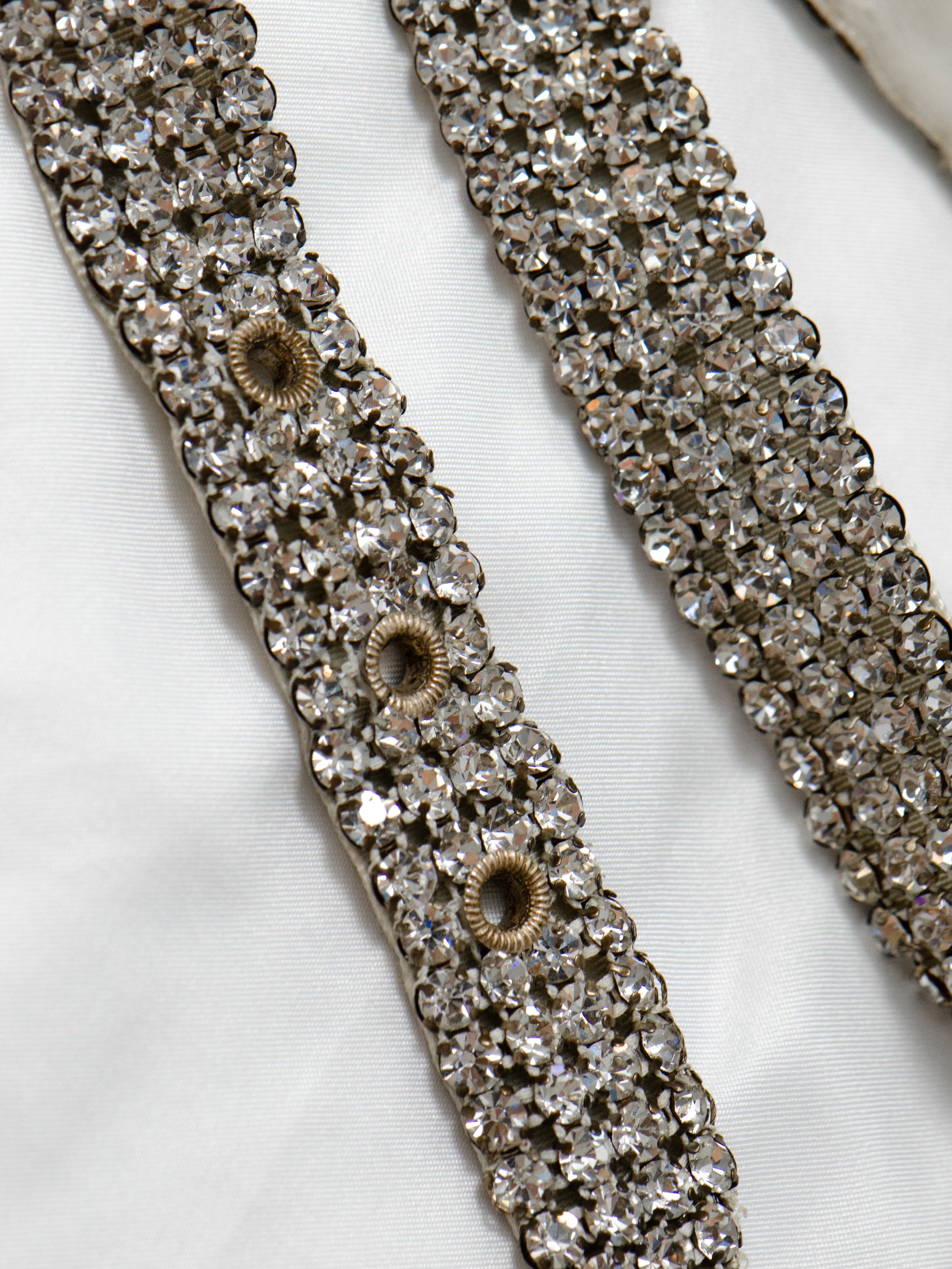 Close-up of the 1950s Austrian rhinestone belt, showing the clear crystals and grommet holes.