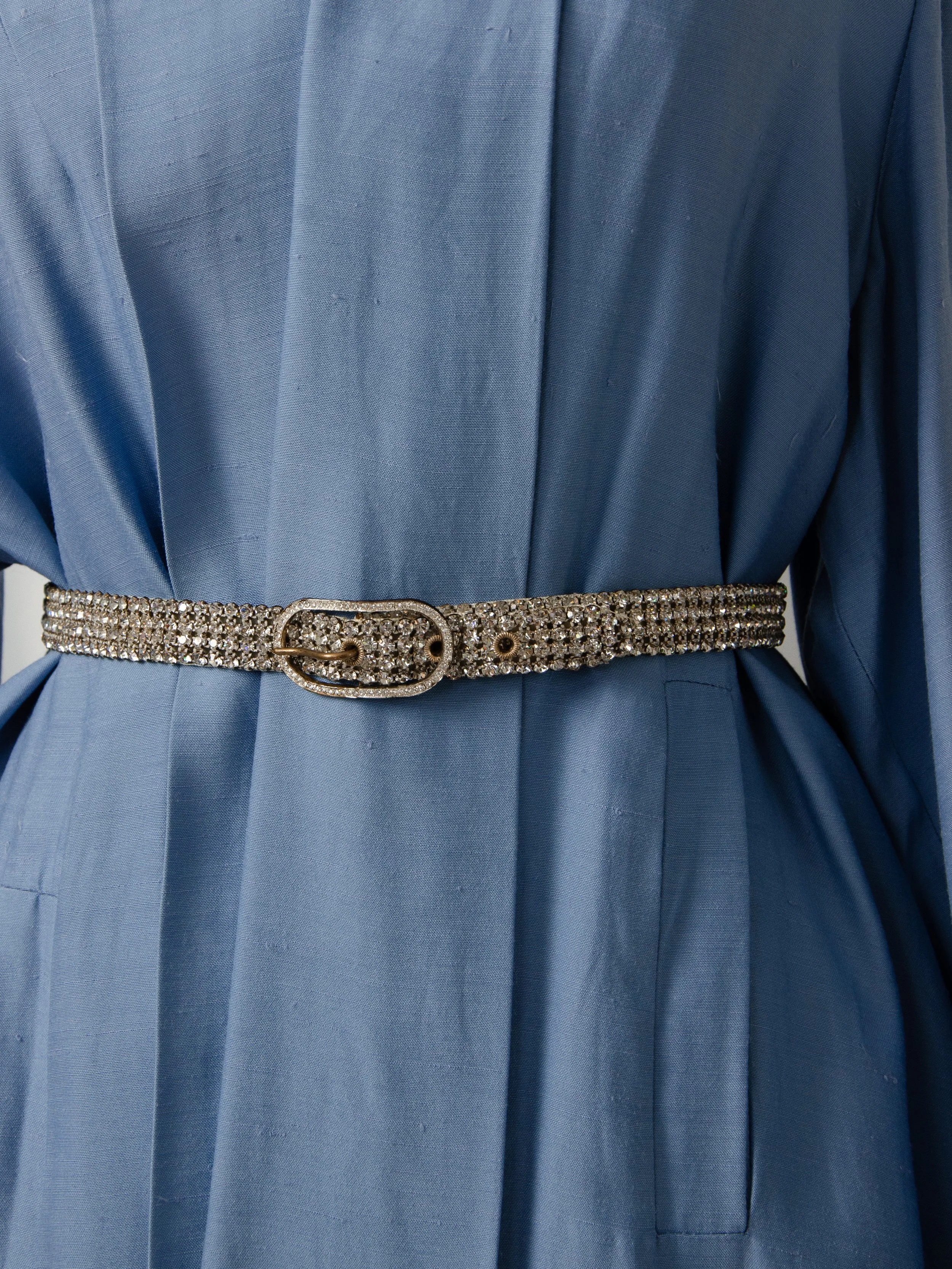 Early 1950s Austrian crystal rhinestone belt worn at the waist over a light blue dress.