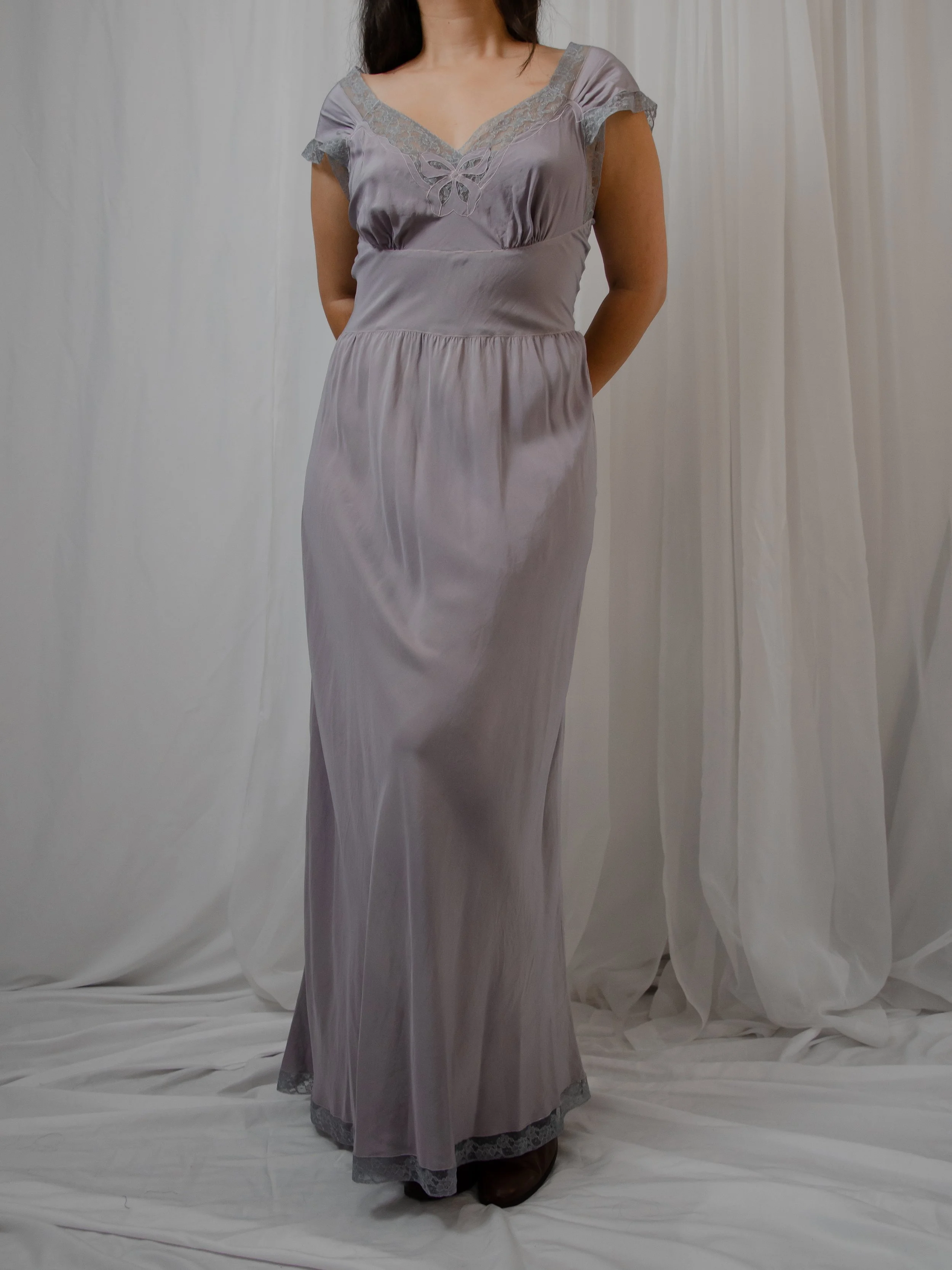 Front view of the 1940s dusty lavender silk dress on a model, showing the long lace-trimmed hem.