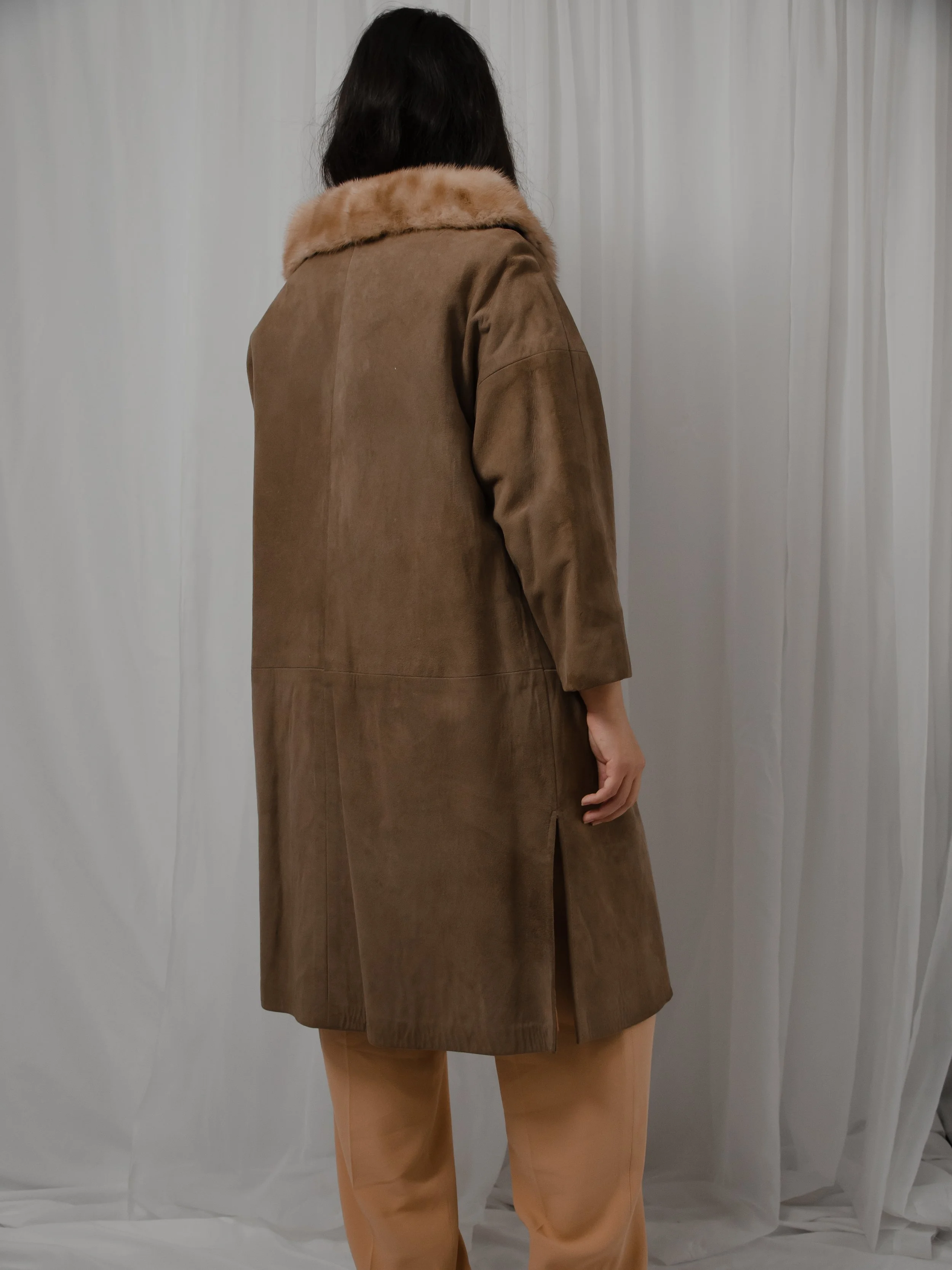 Back view of the 1940s brown suede coat on a model, showing the mink collar and straight back.
