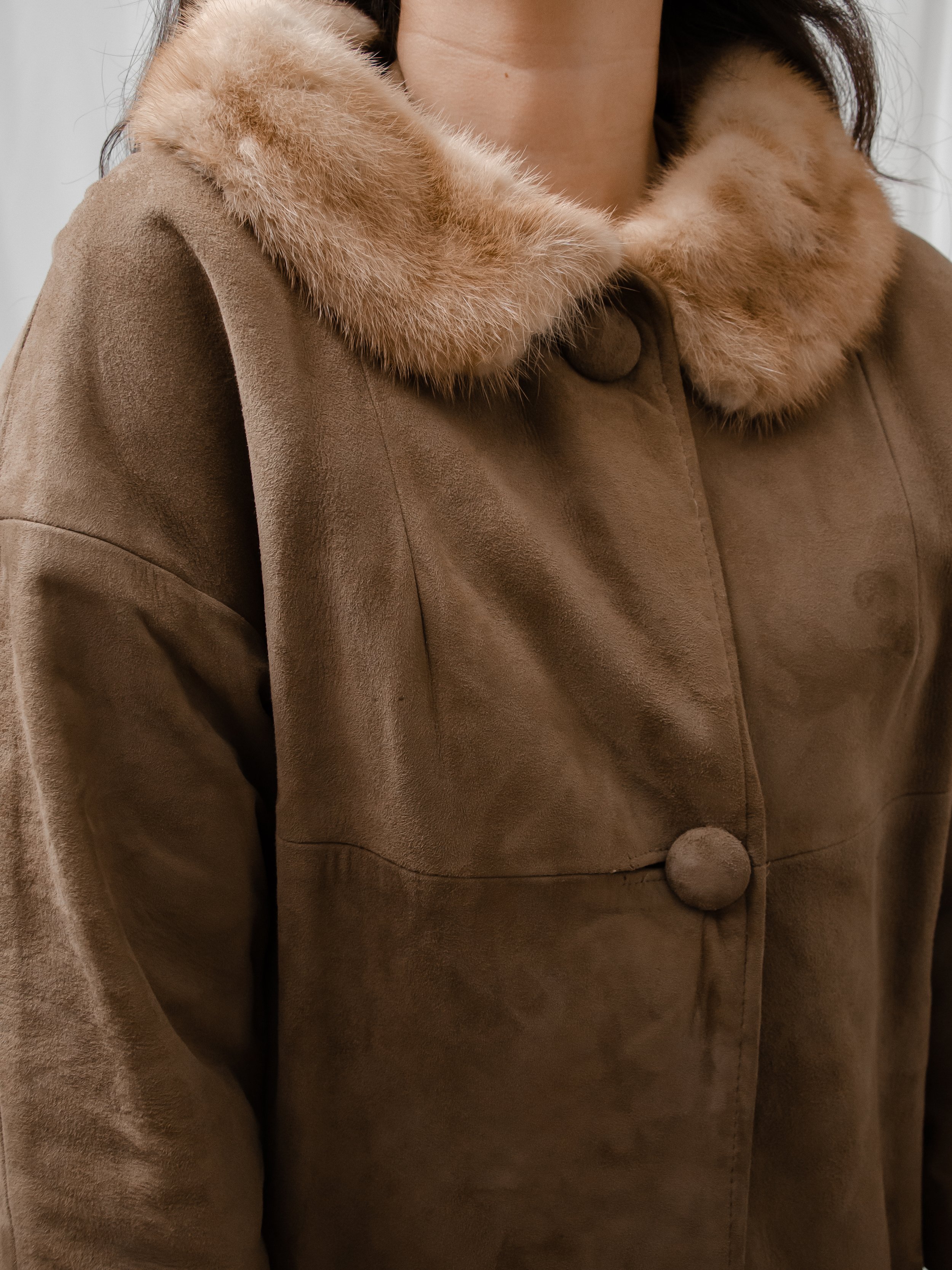 Close-up of the 1940s brown suede coat's mink fur collar and large covered button.