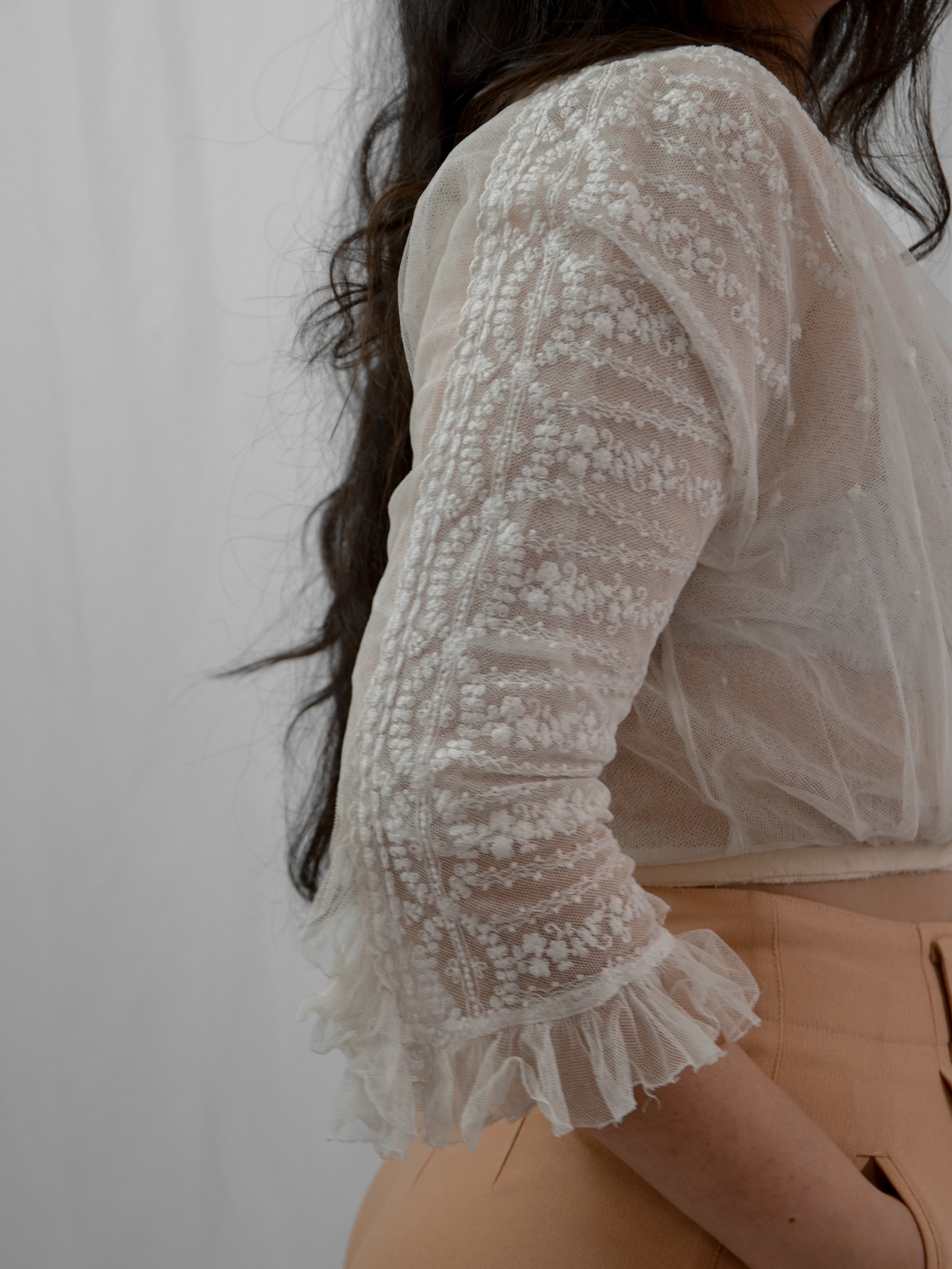 Side view of the Edwardian net blouse on a model, showing floral embroidery down the sleeve and ruffle cuff.