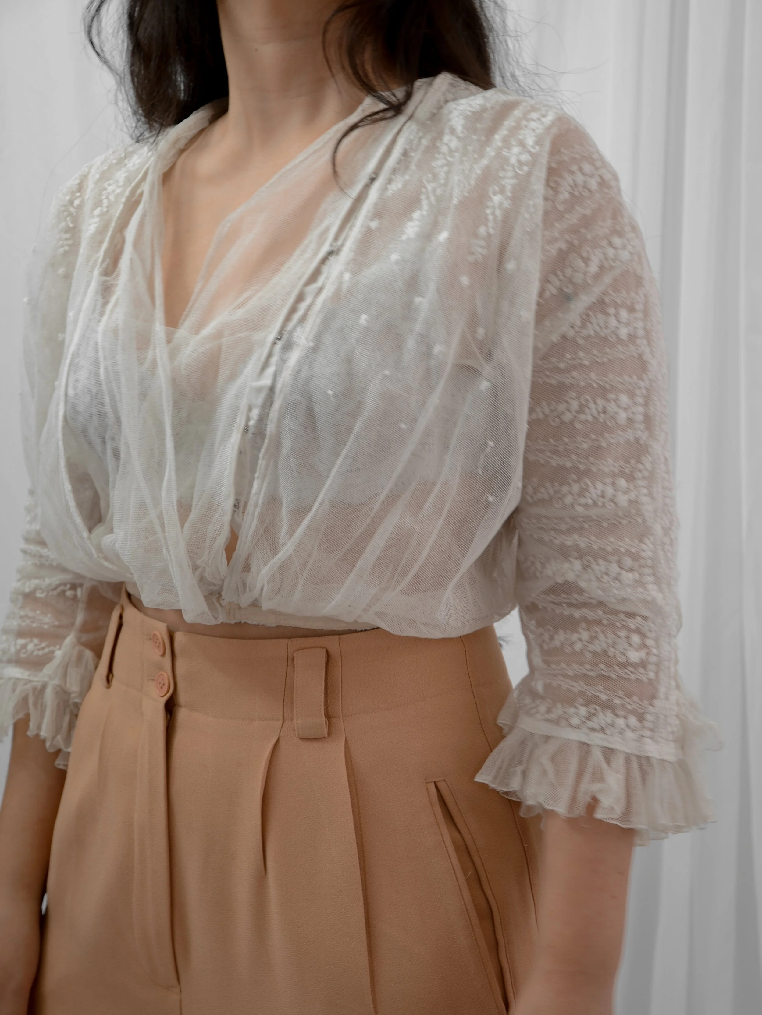 Edwardian embroidered net blouse on a model, three-quarter view showing the draped bodice and ruffle cuffs.
