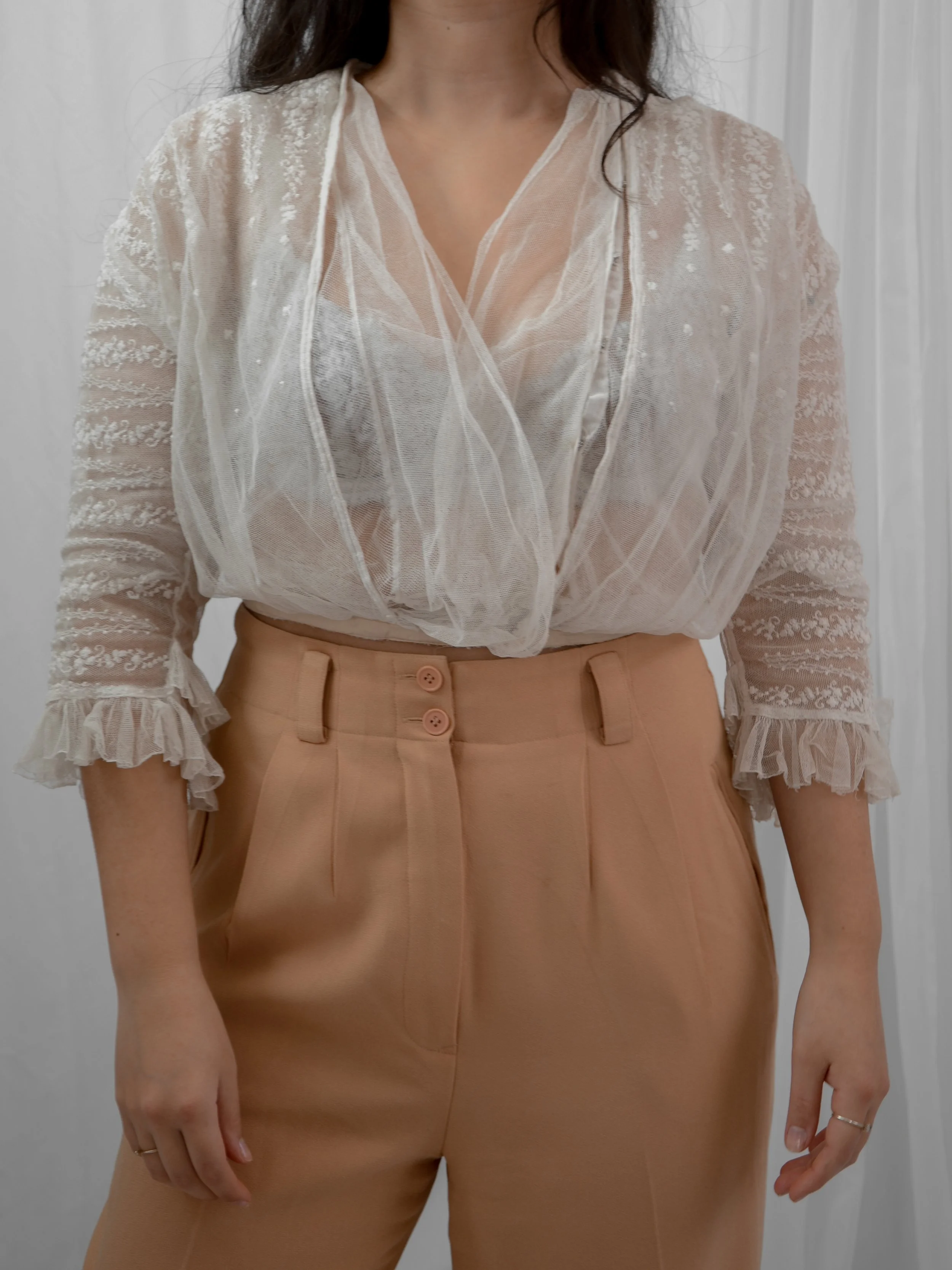 Front view of the 1910s sheer embroidered net blouse on a model, showing ruffled sleeve cuffs.