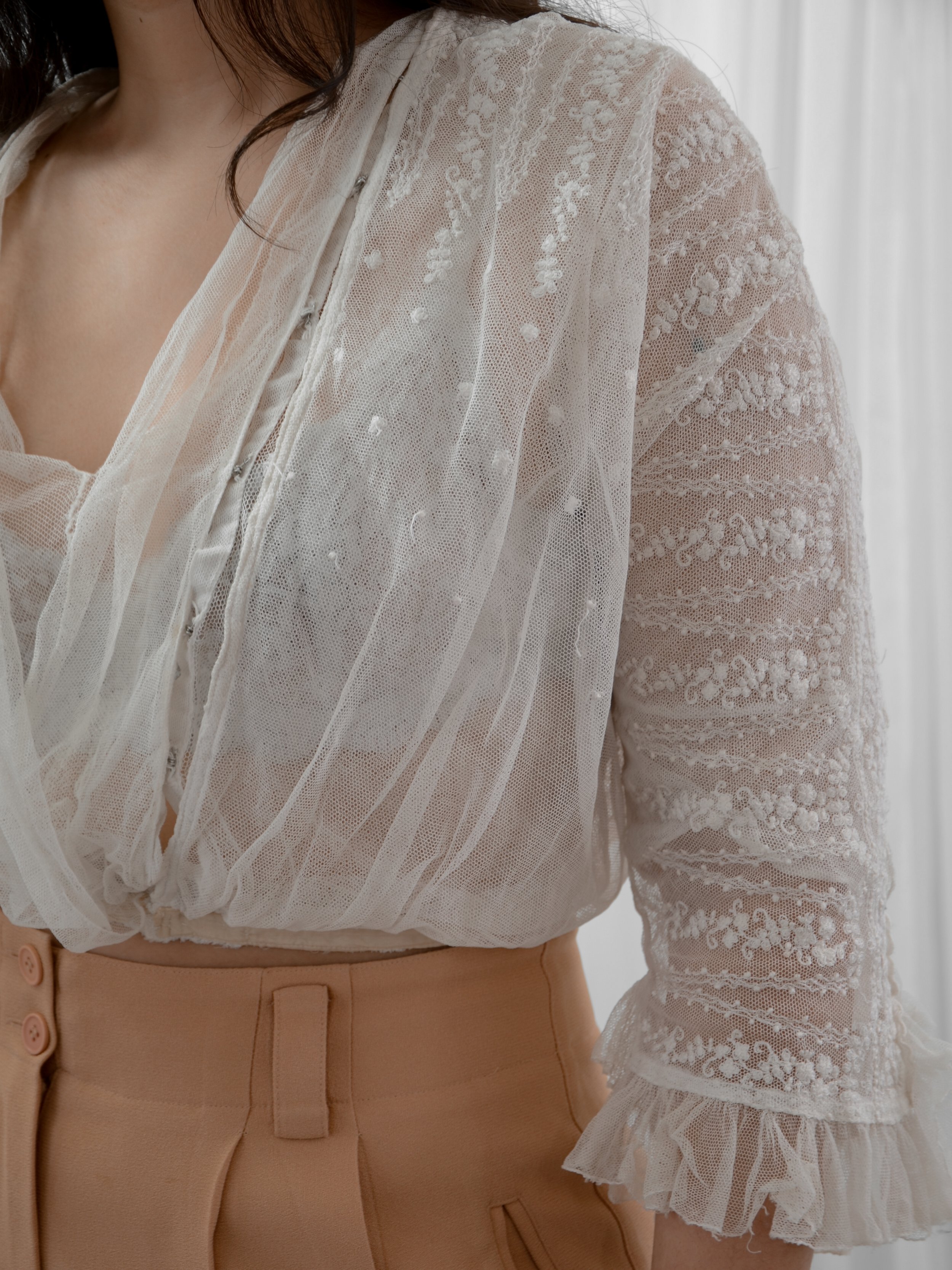 Close-up of the Edwardian net blouse's crossover front and floral embroidered sleeve.