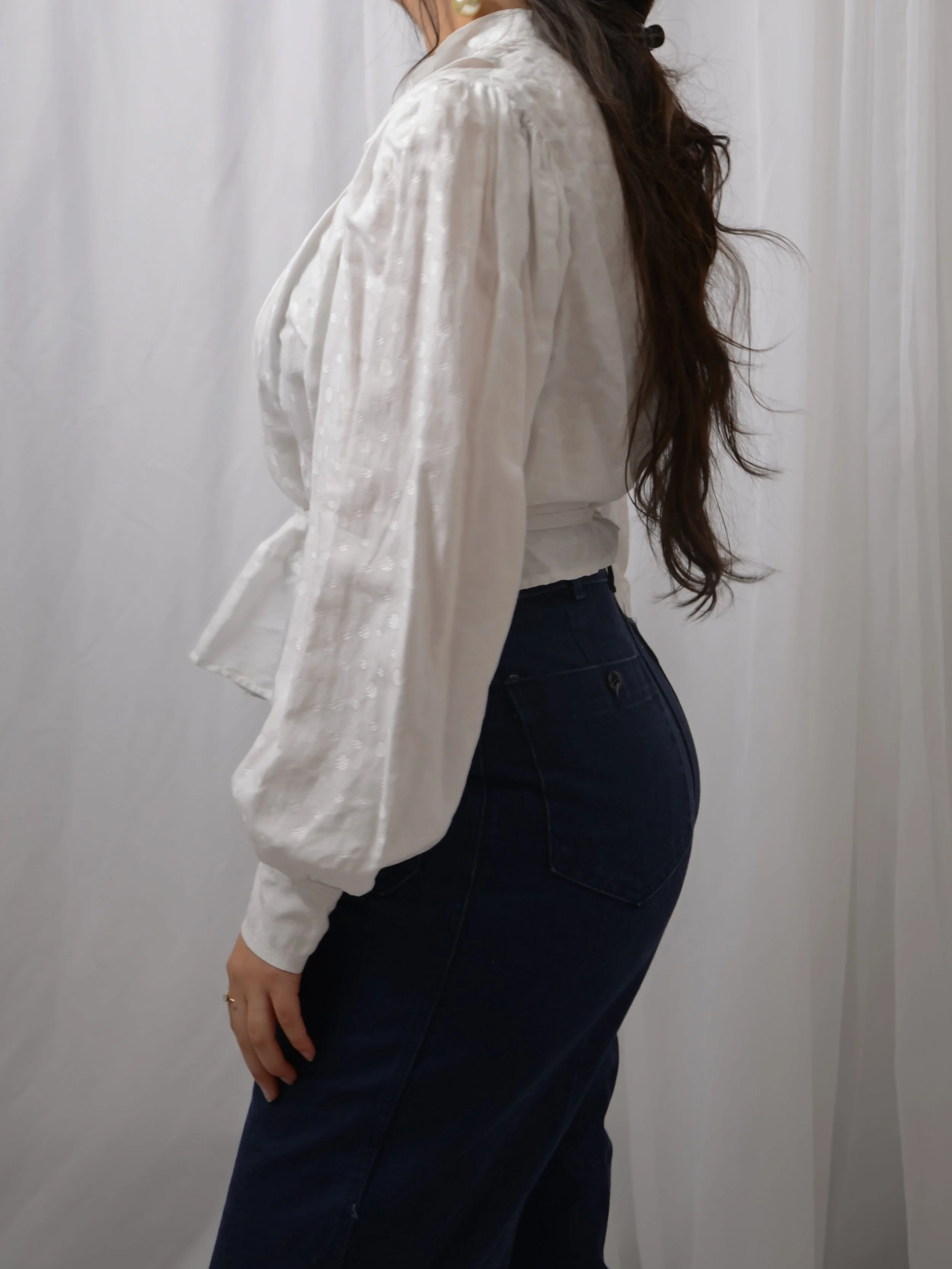 Side view of the Edwardian white dot blouse on a model, showing the puff sleeve and peplum.