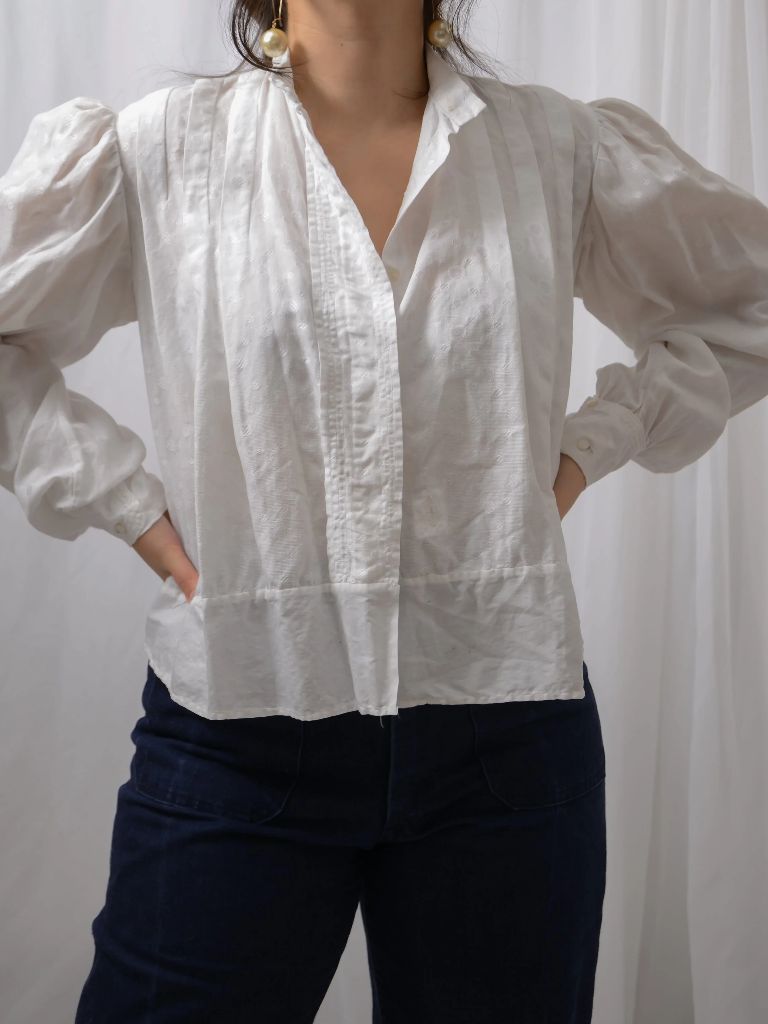 Edwardian white cotton dot blouse worn untied on a model with hands on hips, showing its loose shape.