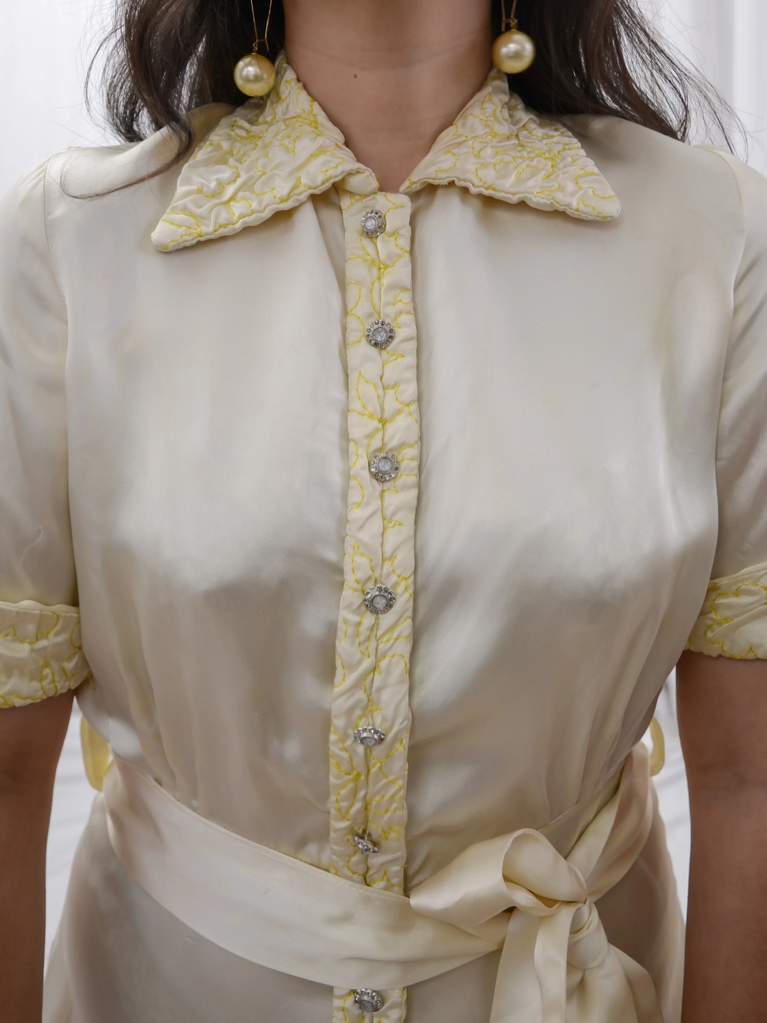 Close-up of the 1940s satin jumpsuit bodice, showing the quilted collar and rhinestone flower buttons.