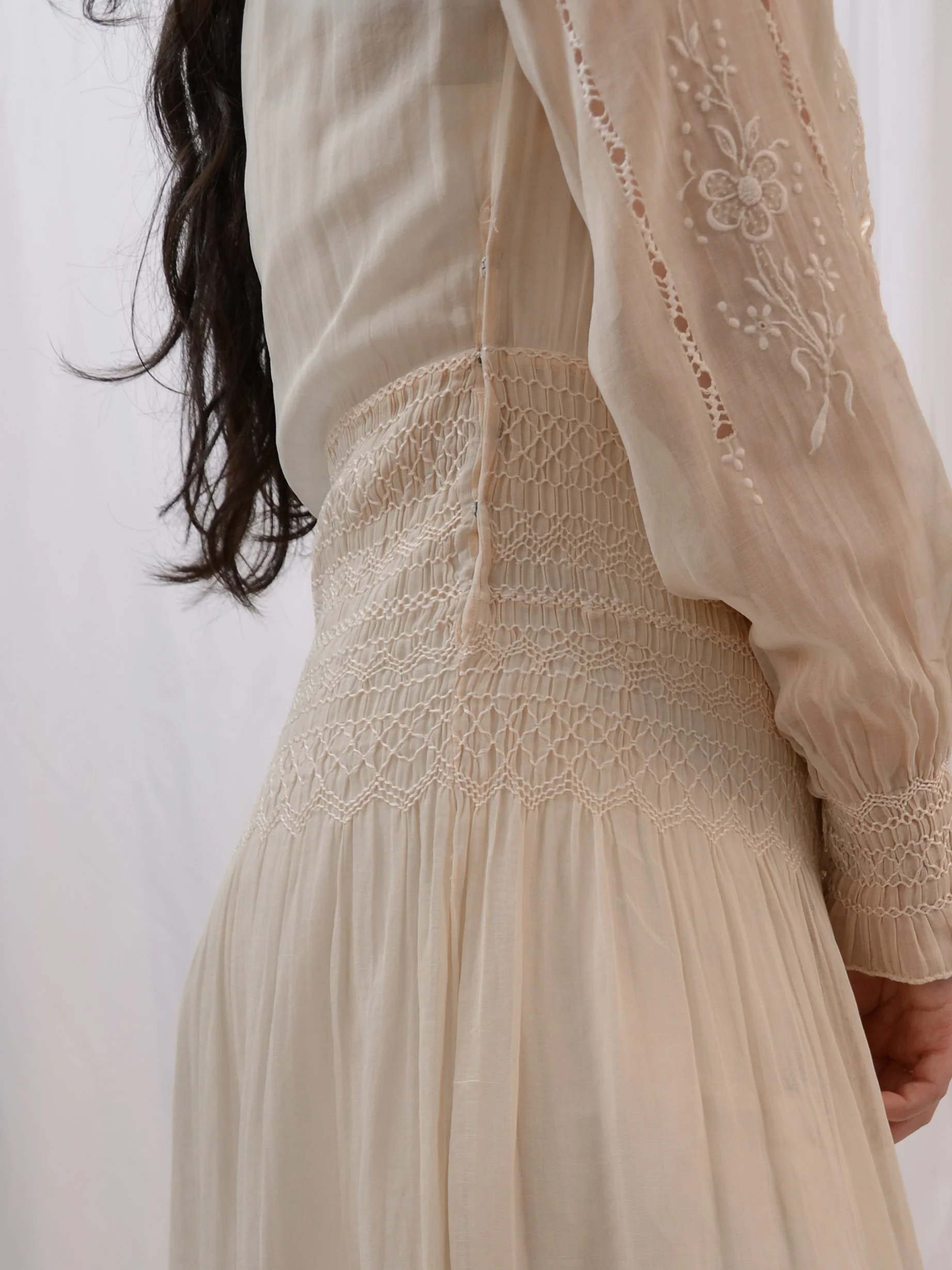 Side detail of the 1920s Hungarian dress on a model, showing the honeycomb smocked waist and sleeve.