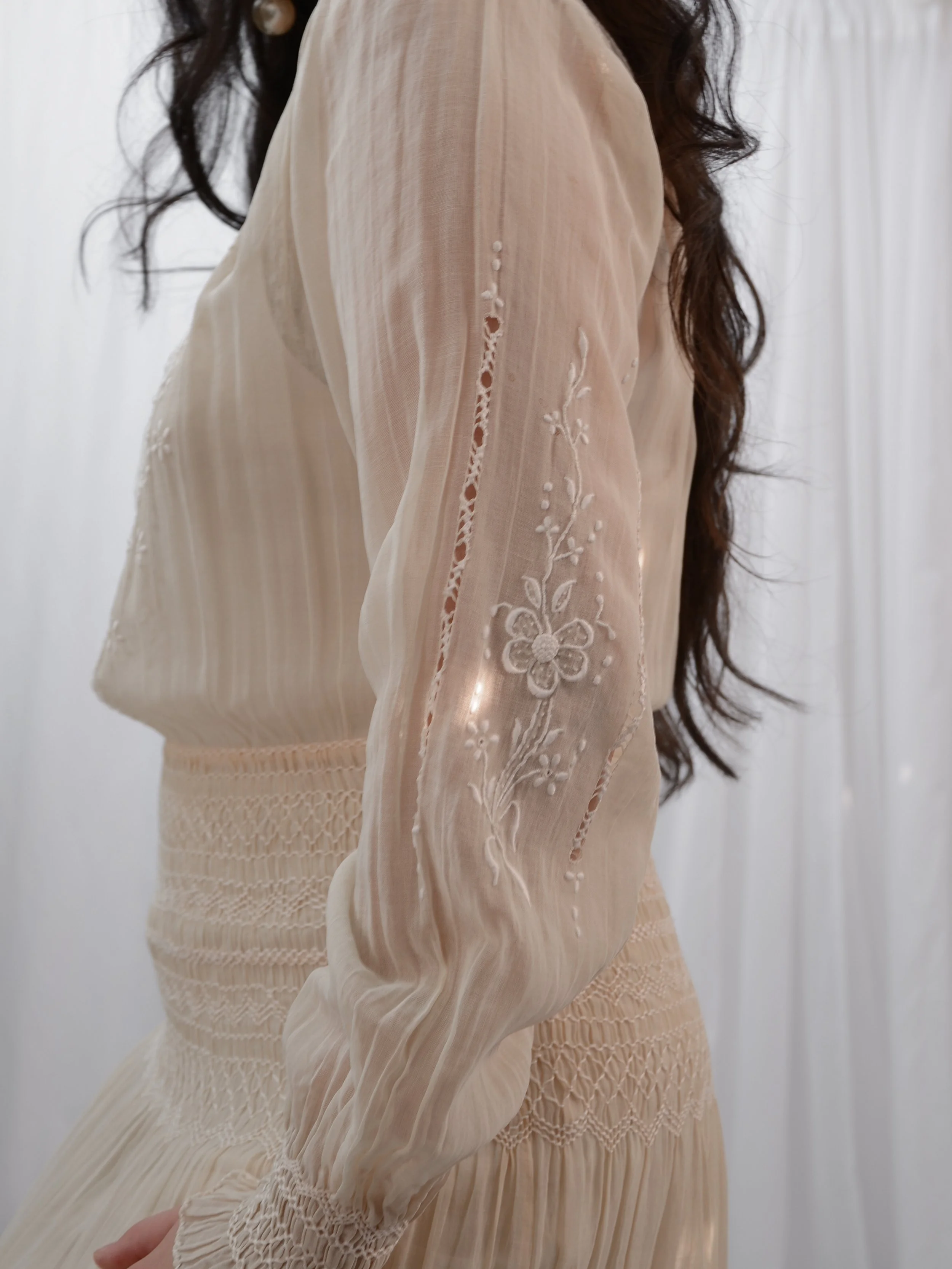 Side view of the 1920s Hungarian dress sleeve on a model, showing whitework embroidery and openwork.