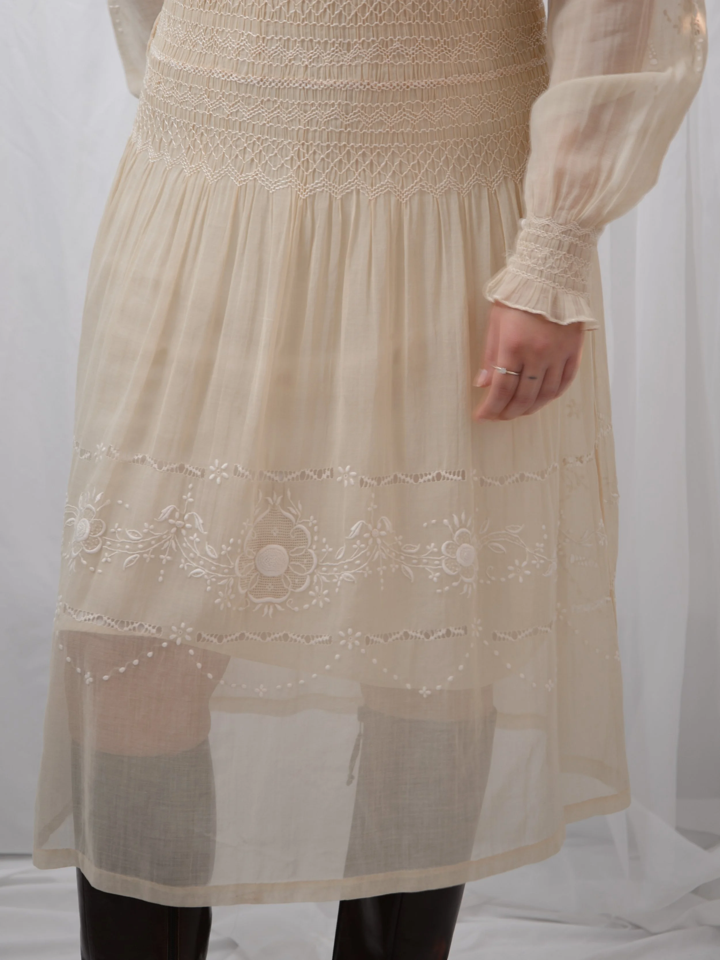 Detail of the 1920s ecru voile dress skirt below the smocked waist, showing embroidered bands.