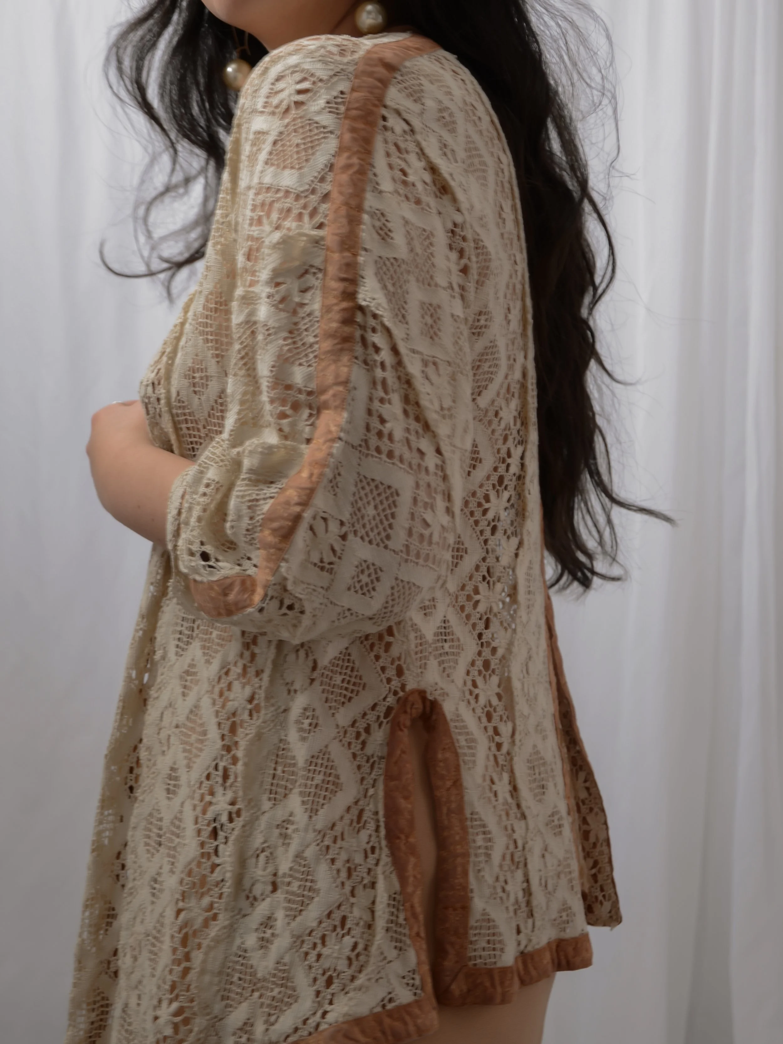 Close-up side view of the Edwardian lace jacket on a model, showing the puff sleeve and velvet edging.