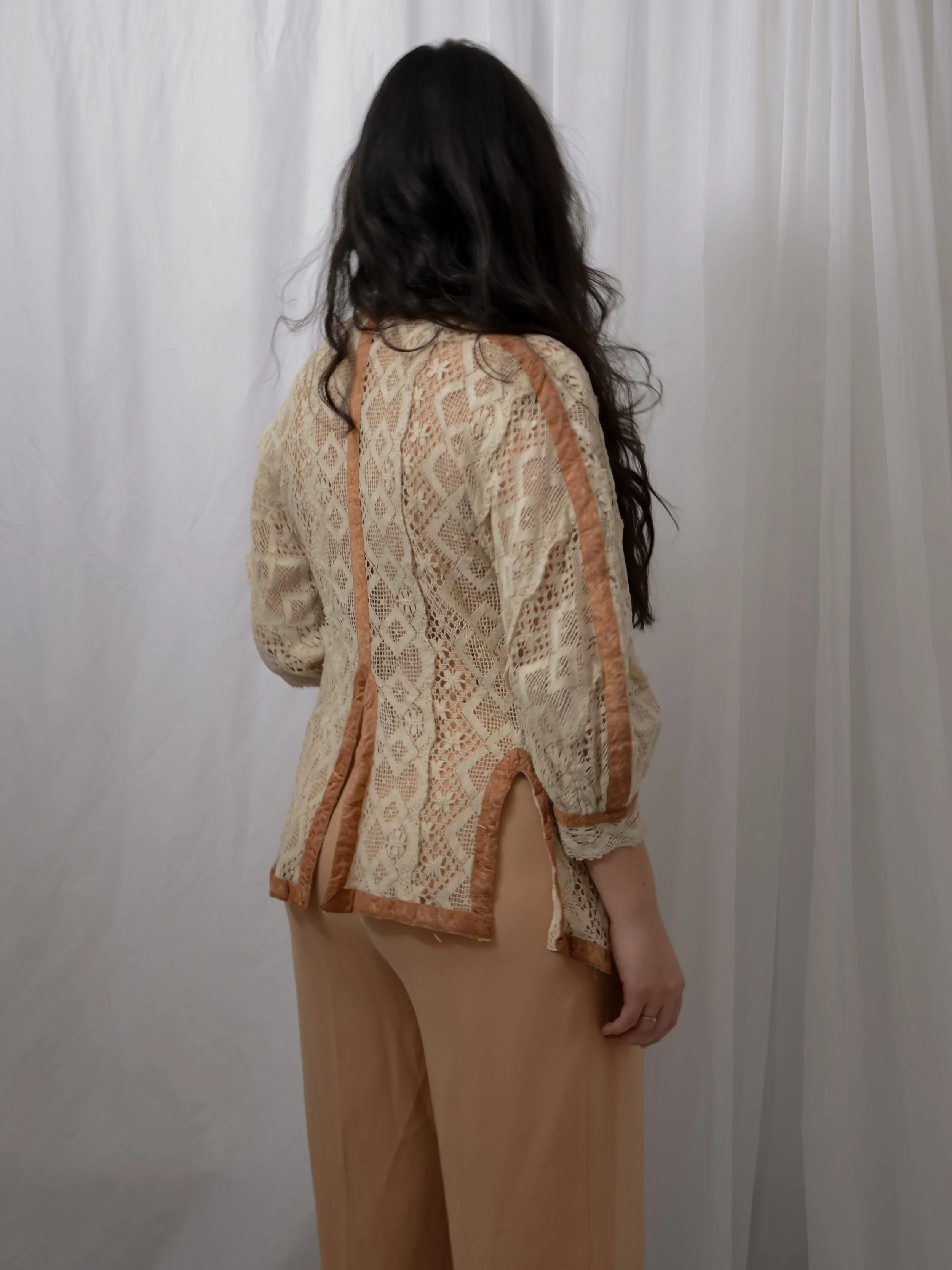 Back view of the 1910s ecru cotton lace jacket on a model, showing the velvet trims and back vents.