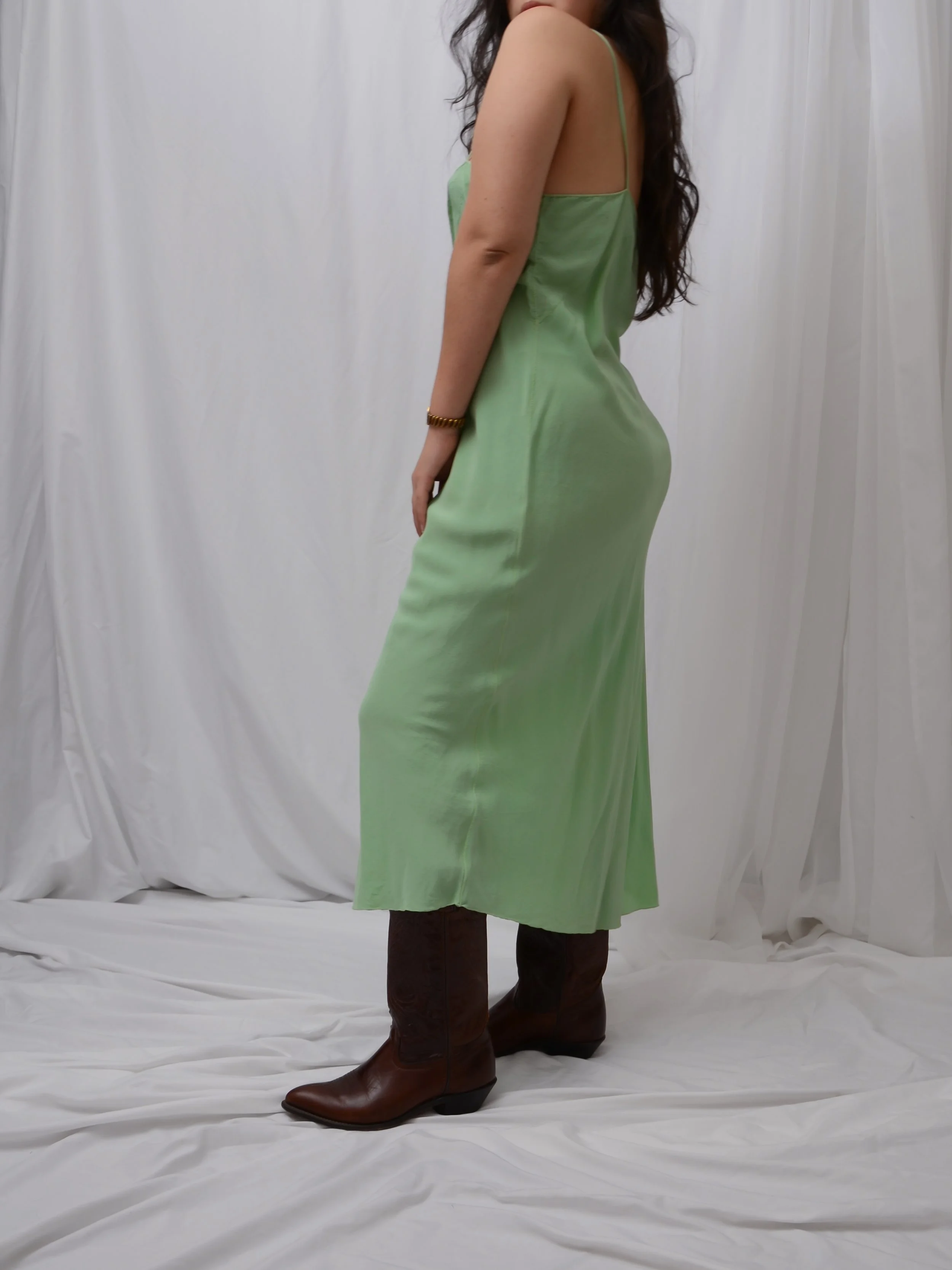Side view of the 1920s sage green silk slip dress on a model, showing the fluid drape.