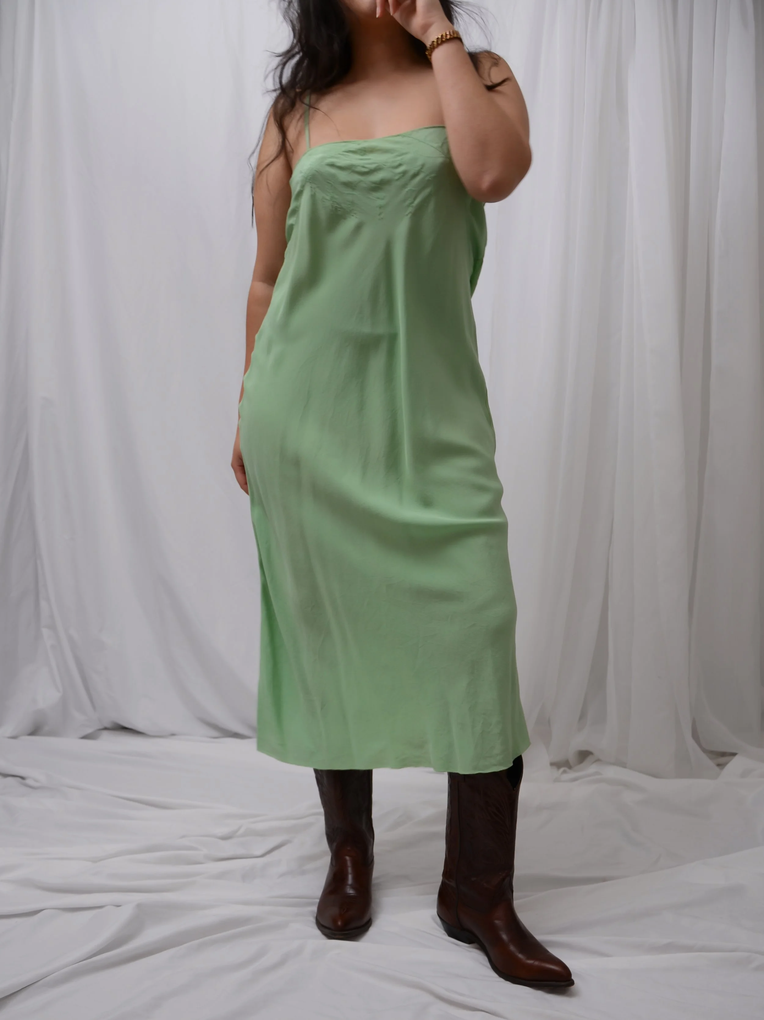 Late 1920s sage green silk slip dress on a model, three-quarter front view with thin straps.