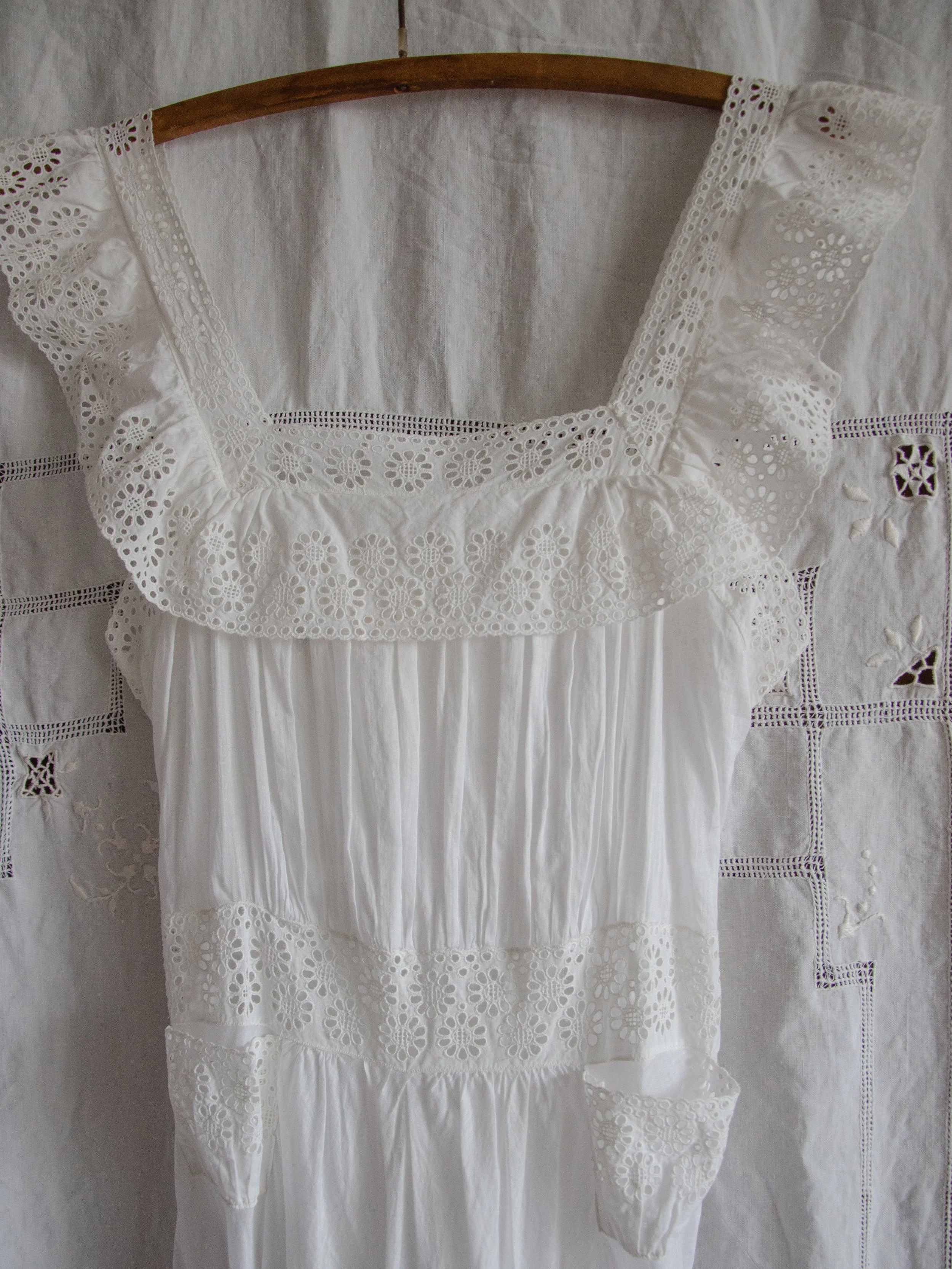 Close-up of the 1940s white slip dress's eyelet lace ruffle neckline and eyelet waistband with hip pocket.