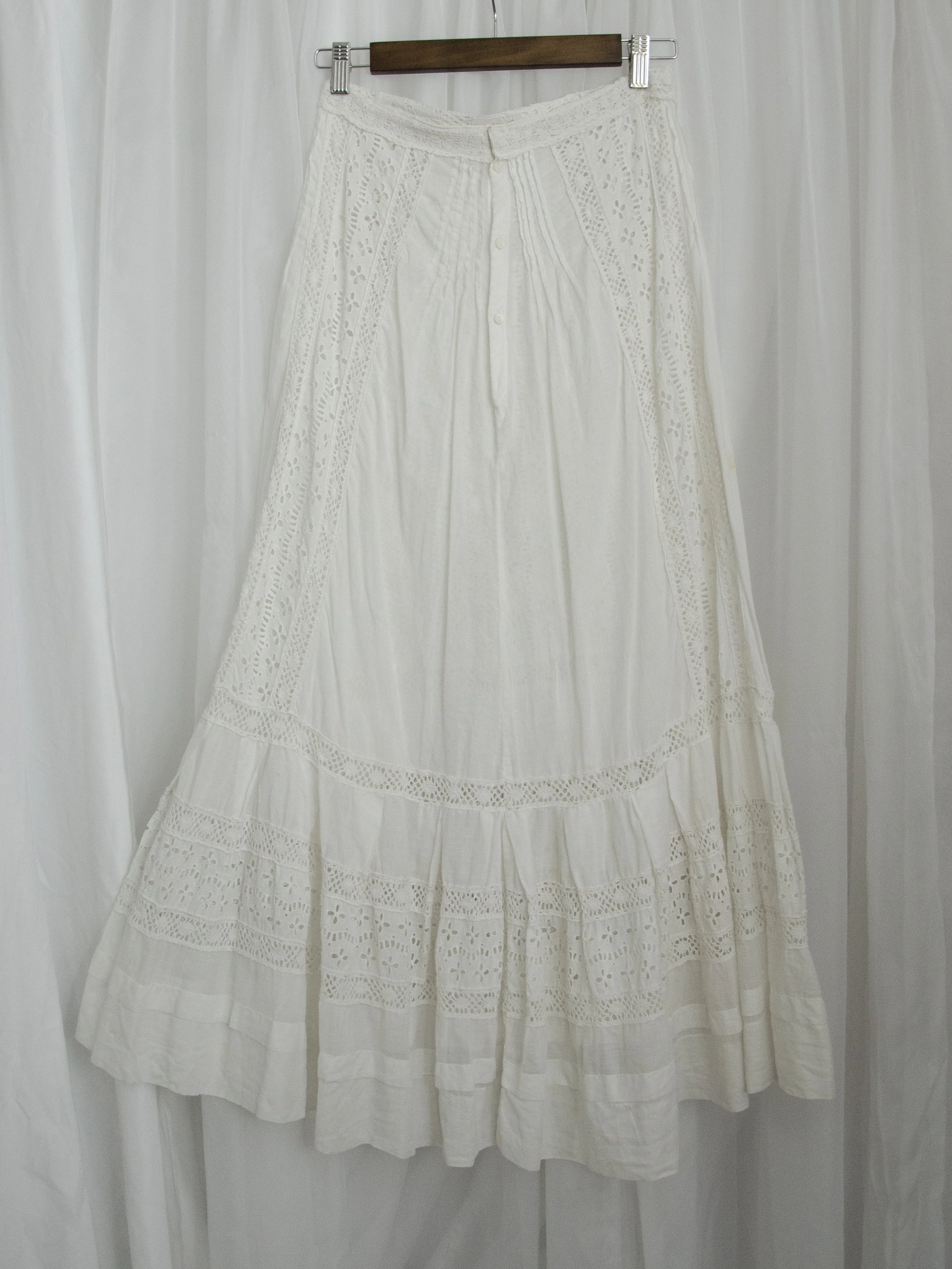 Edwardian white eyelet skirt on a hanger, full front view showing the tiered lace hem.