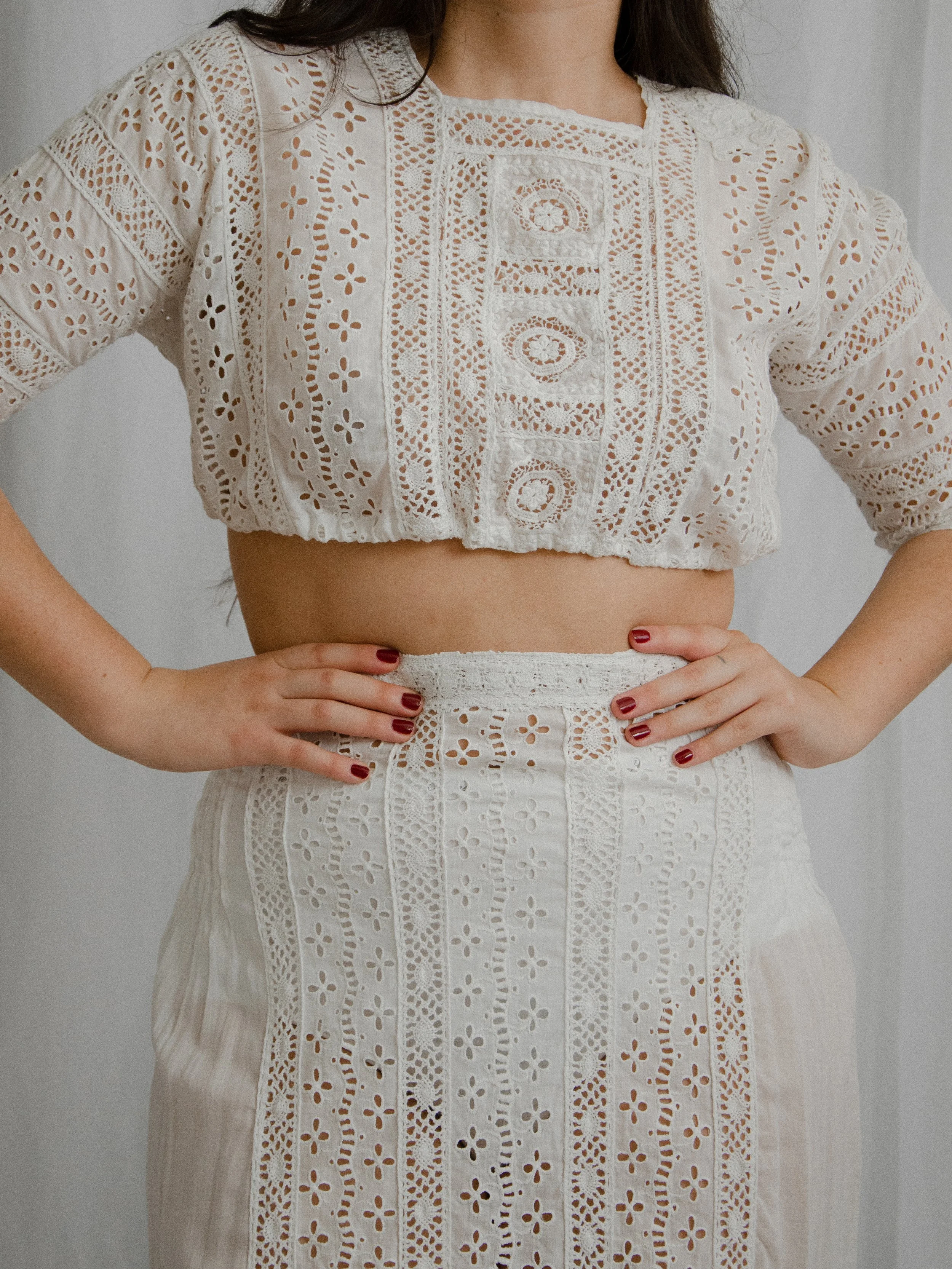 Close-up of the Edwardian cropped eyelet top on a model with hands on hips, showing lace and eyelet bands.