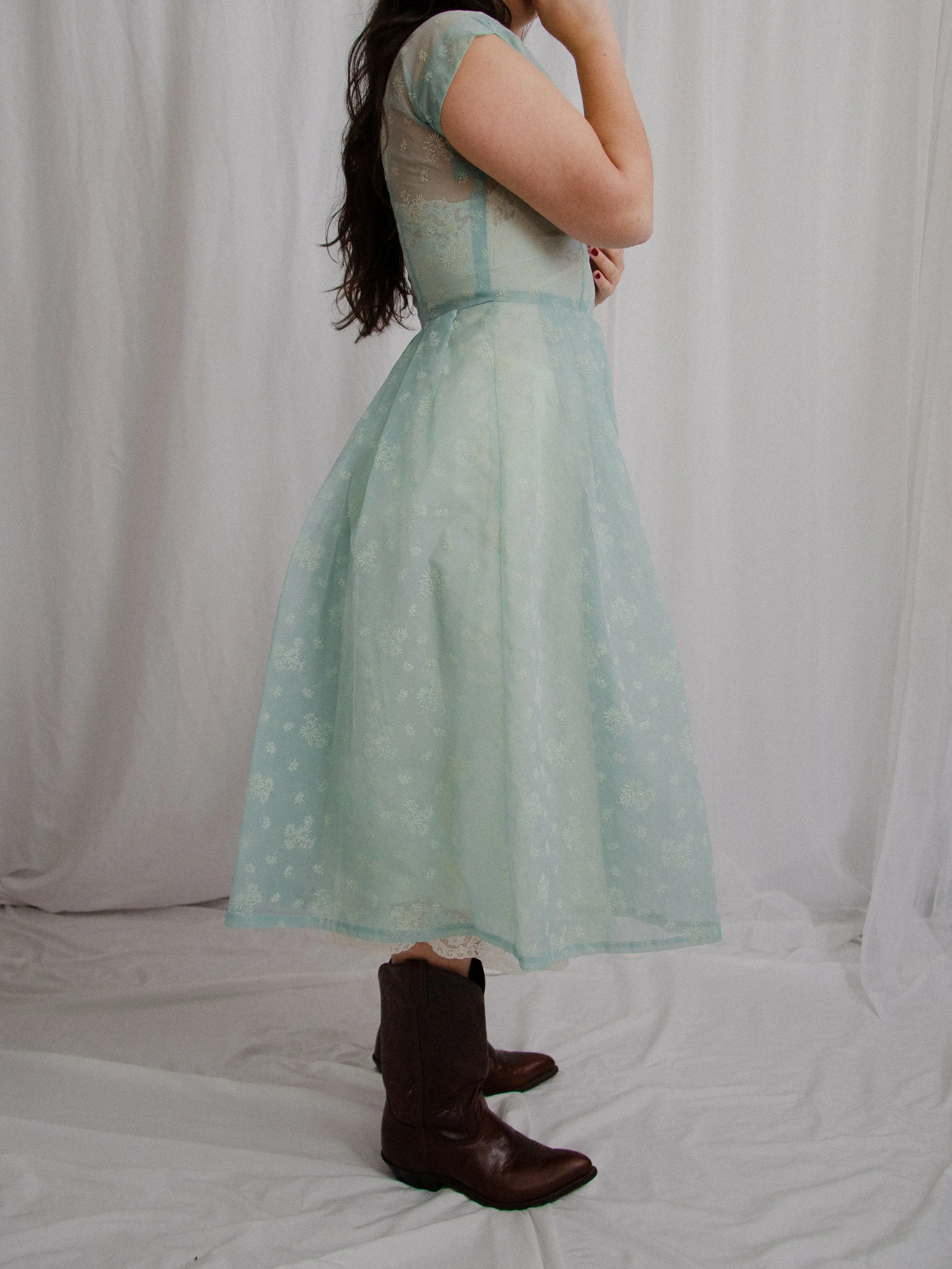 Side view of the 1950s robin's egg blue sheer daisy dress on a model, showing the full skirt.