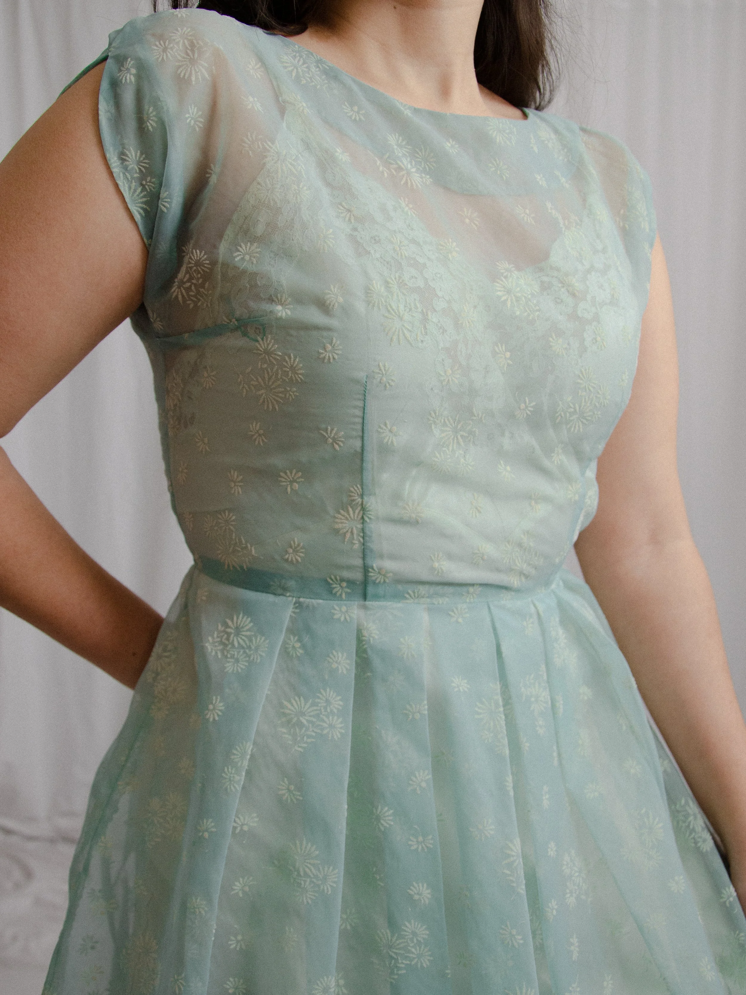 Close-up of the 1950s robin's egg blue sheer dress bodice on a model, showing the boat neckline.