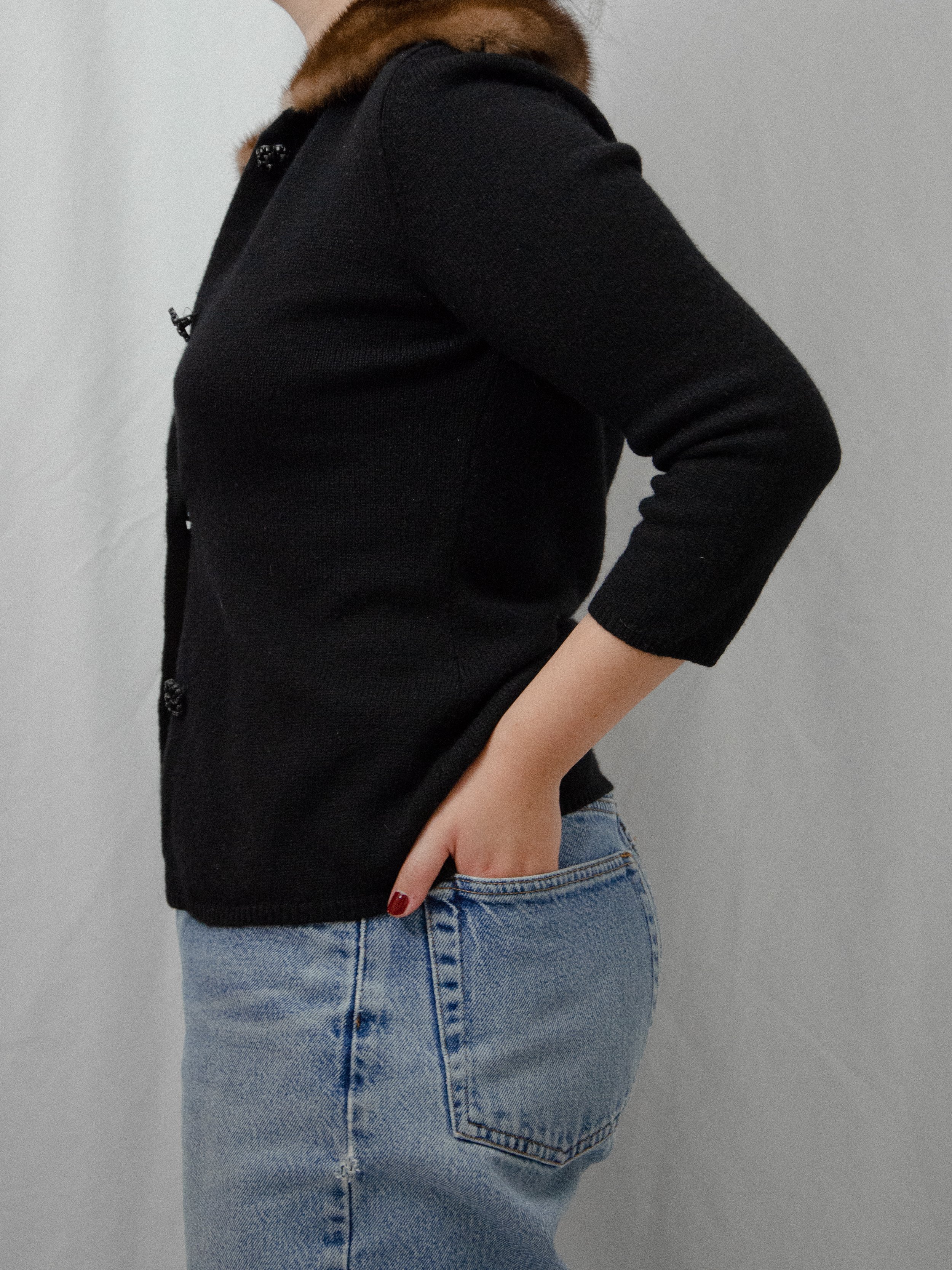 Side view of the 1940s black knit cardigan on a model, showing the three-quarter sleeves.