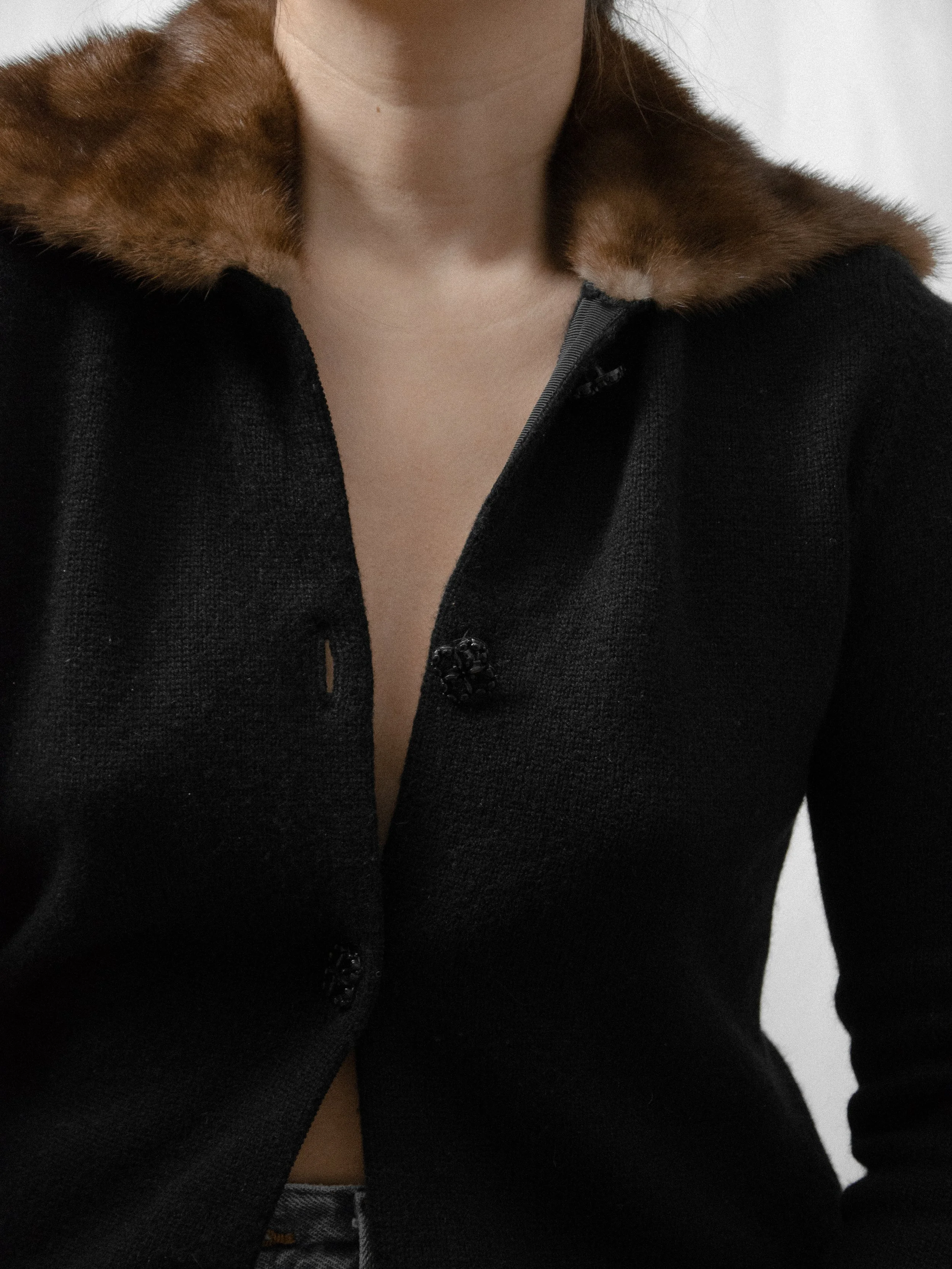 Close-up of the 1940s black knit cardigan's brown mink fur collar and front buttons.