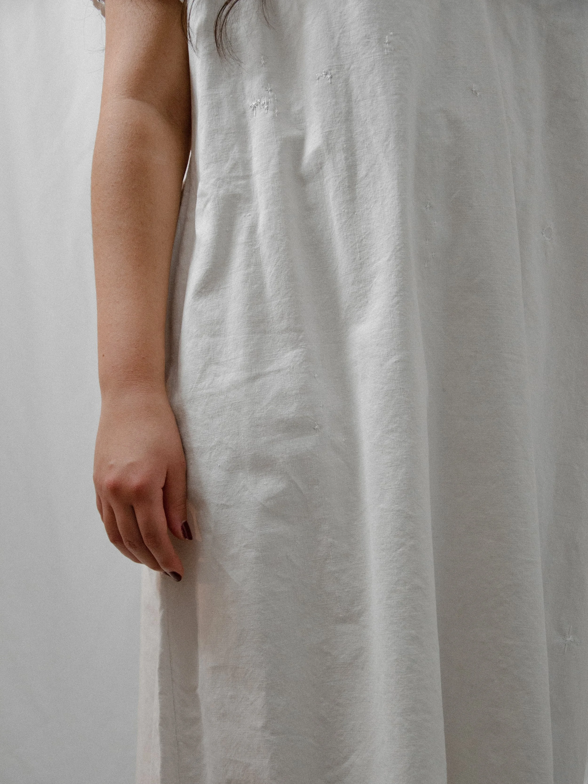 Detail of the Victorian white cotton smock dress at the side, showing the short sleeve and heavy cotton.