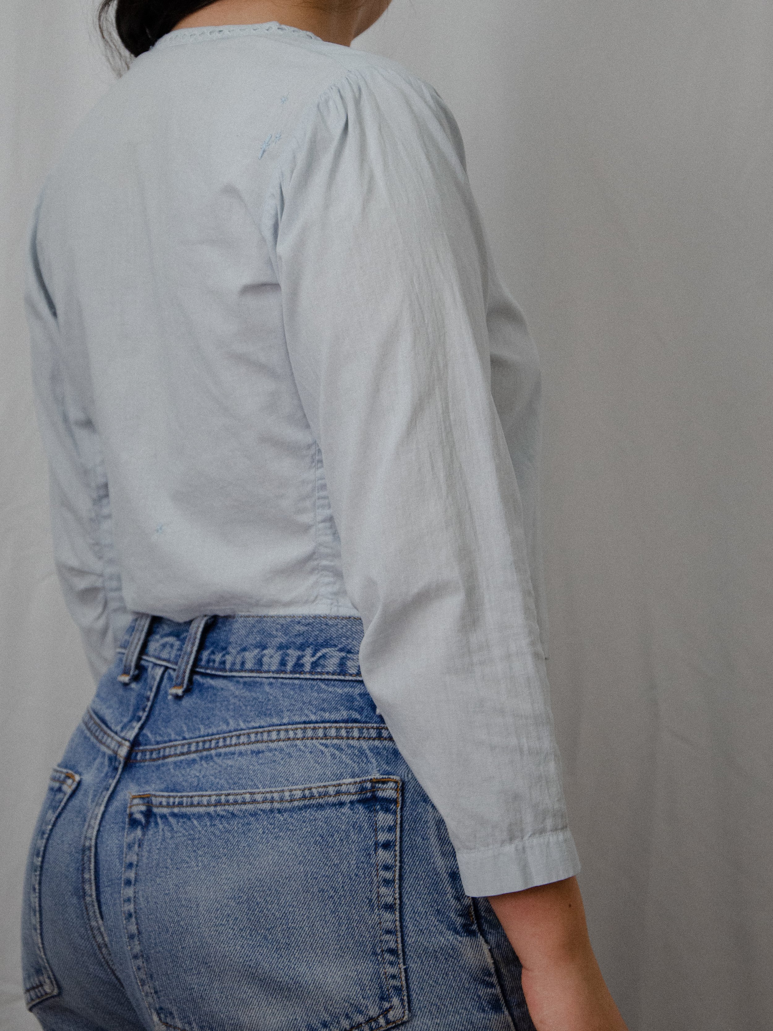 Back view of the 'Bluebell' light blue antique cotton top on a model, showing the gathered shoulders.