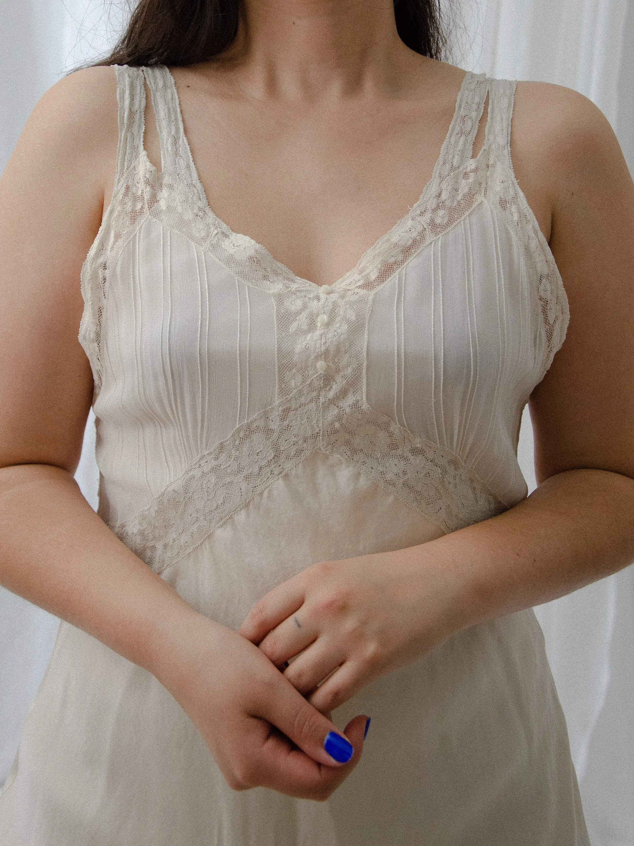 Close-up of the 1930s ivory silk slip dress bodice, showing the sheer pintucked bust and lace inserts.