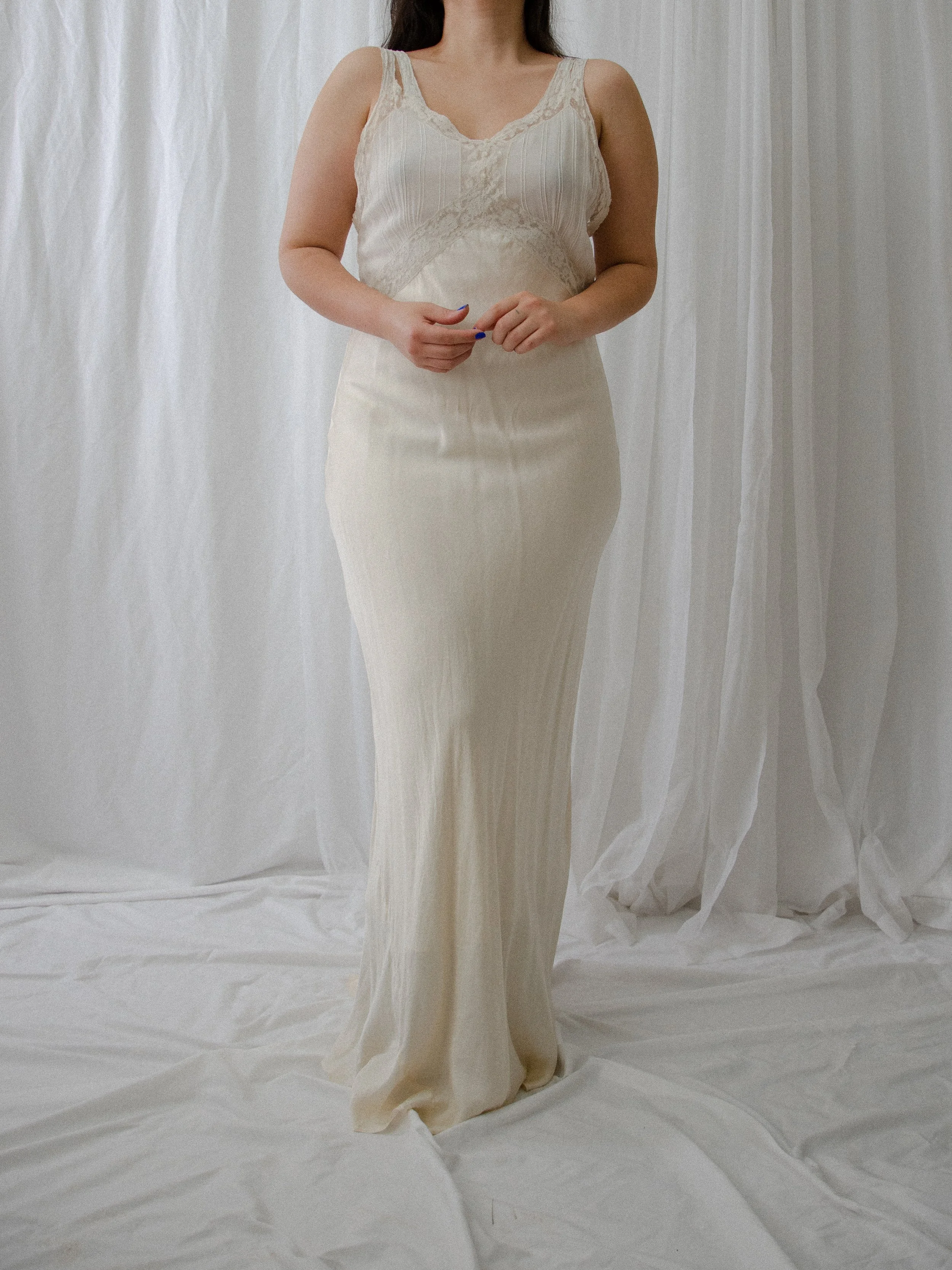 Front view of the 1930s ivory silk bias-cut slip dress on a model, showing the long fitted silhouette.