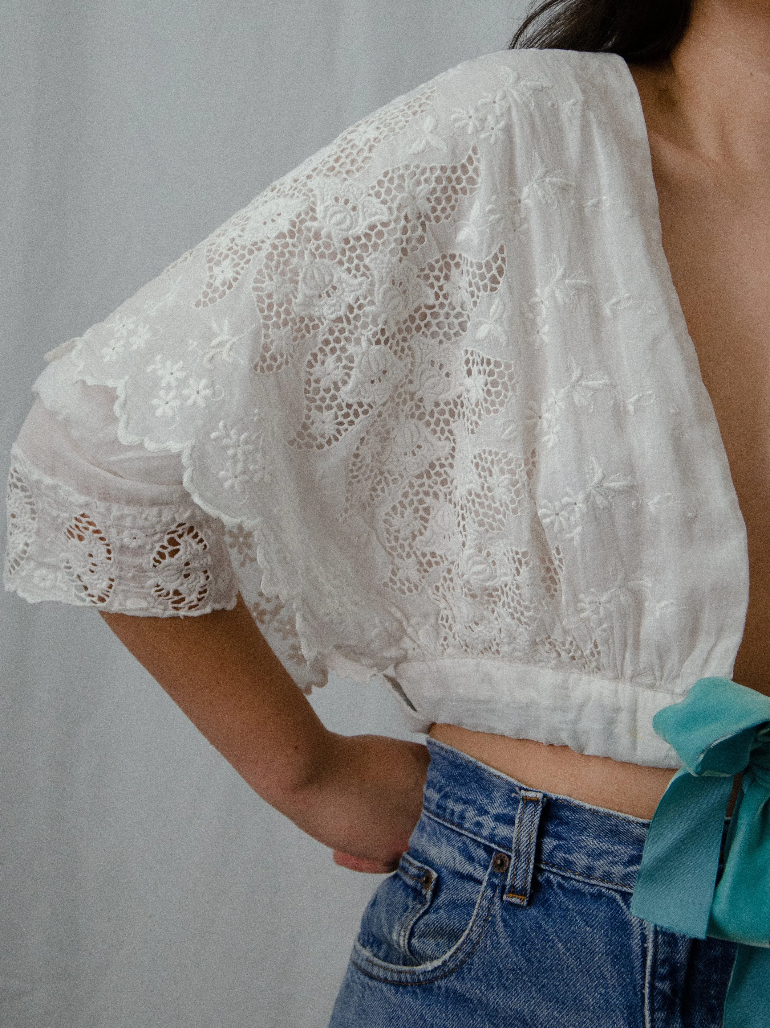 Close-up of the antique white wrap blouse's wide lace and embroidered butterfly sleeve.