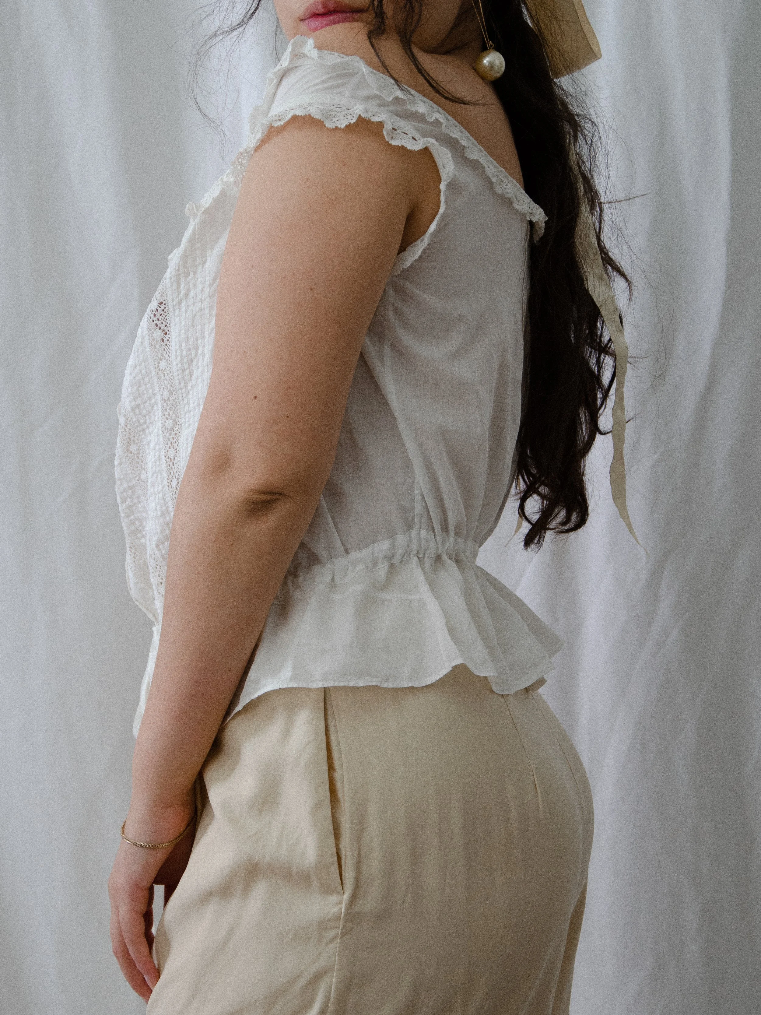 Side view of the antique white corset cover on a model, showing the cap sleeve and gathered peplum.