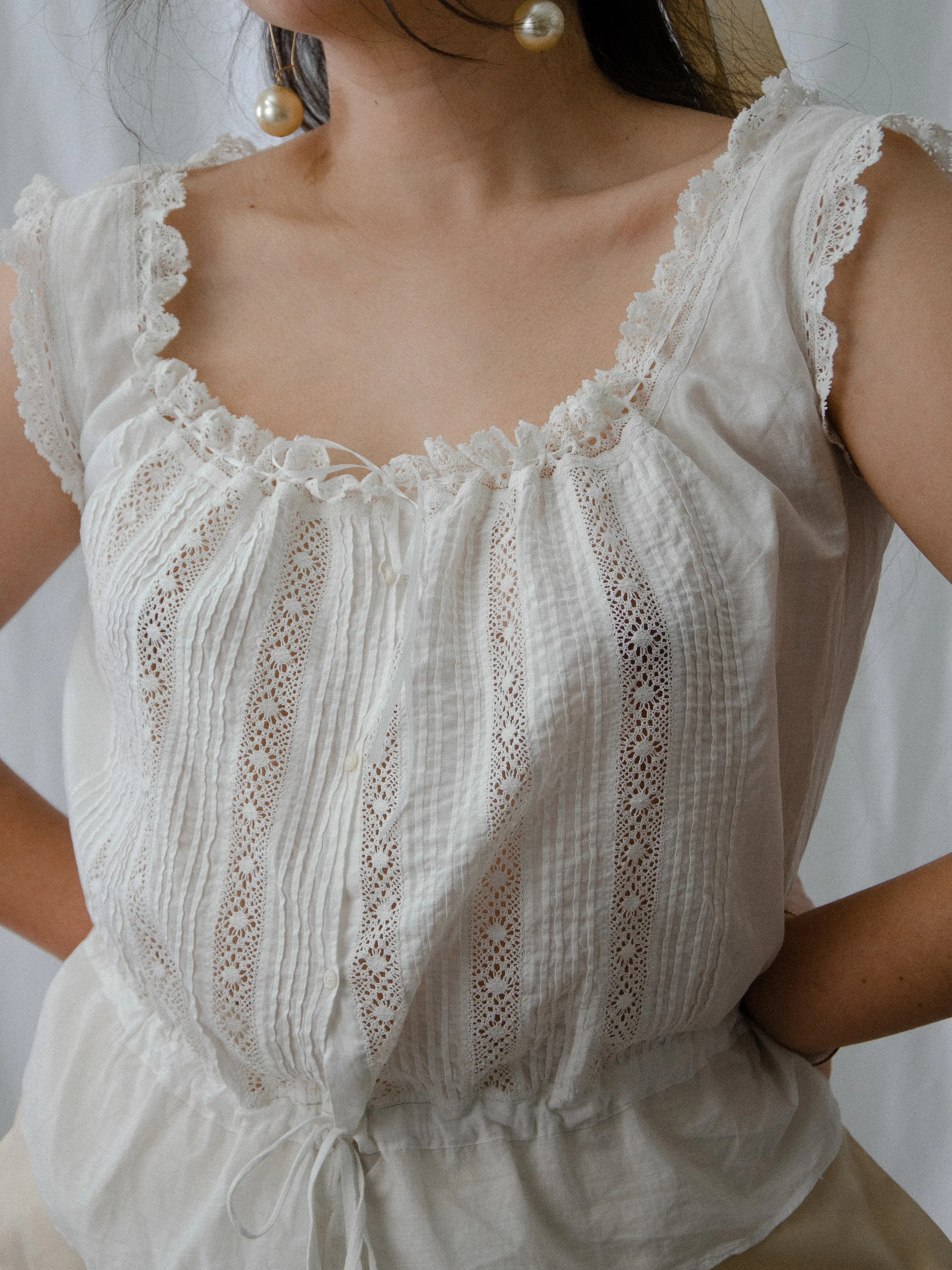 Close-up of the antique corset cover's scoop neckline with lace edging and vertical lace insertions.