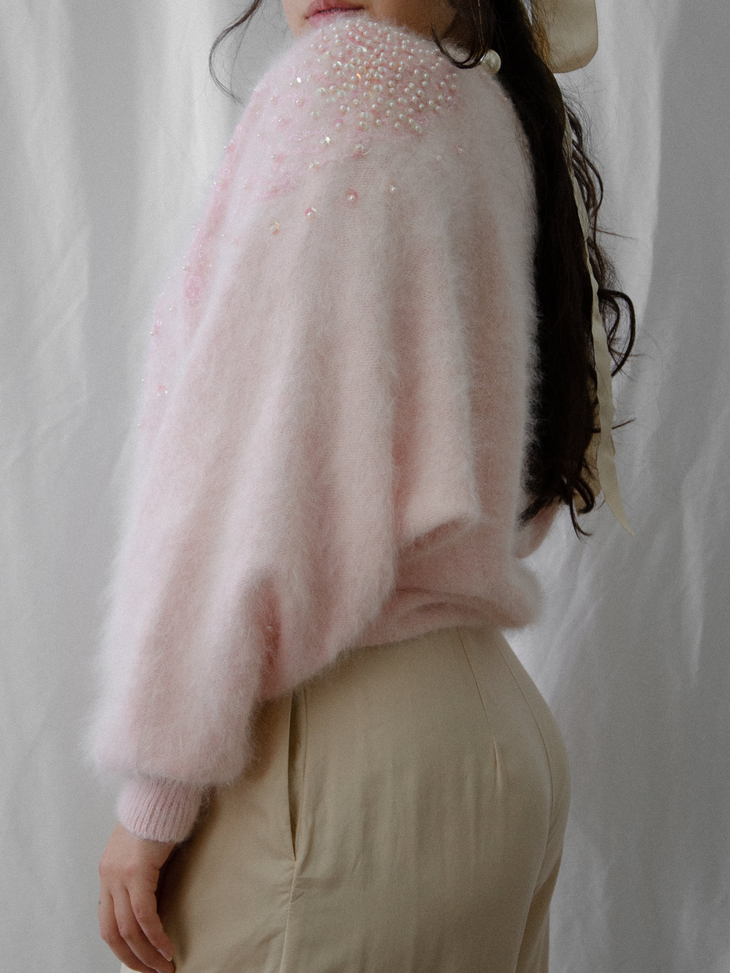 Back view of the 1980s pink angora sweater on a model, showing sequins at the shoulder.