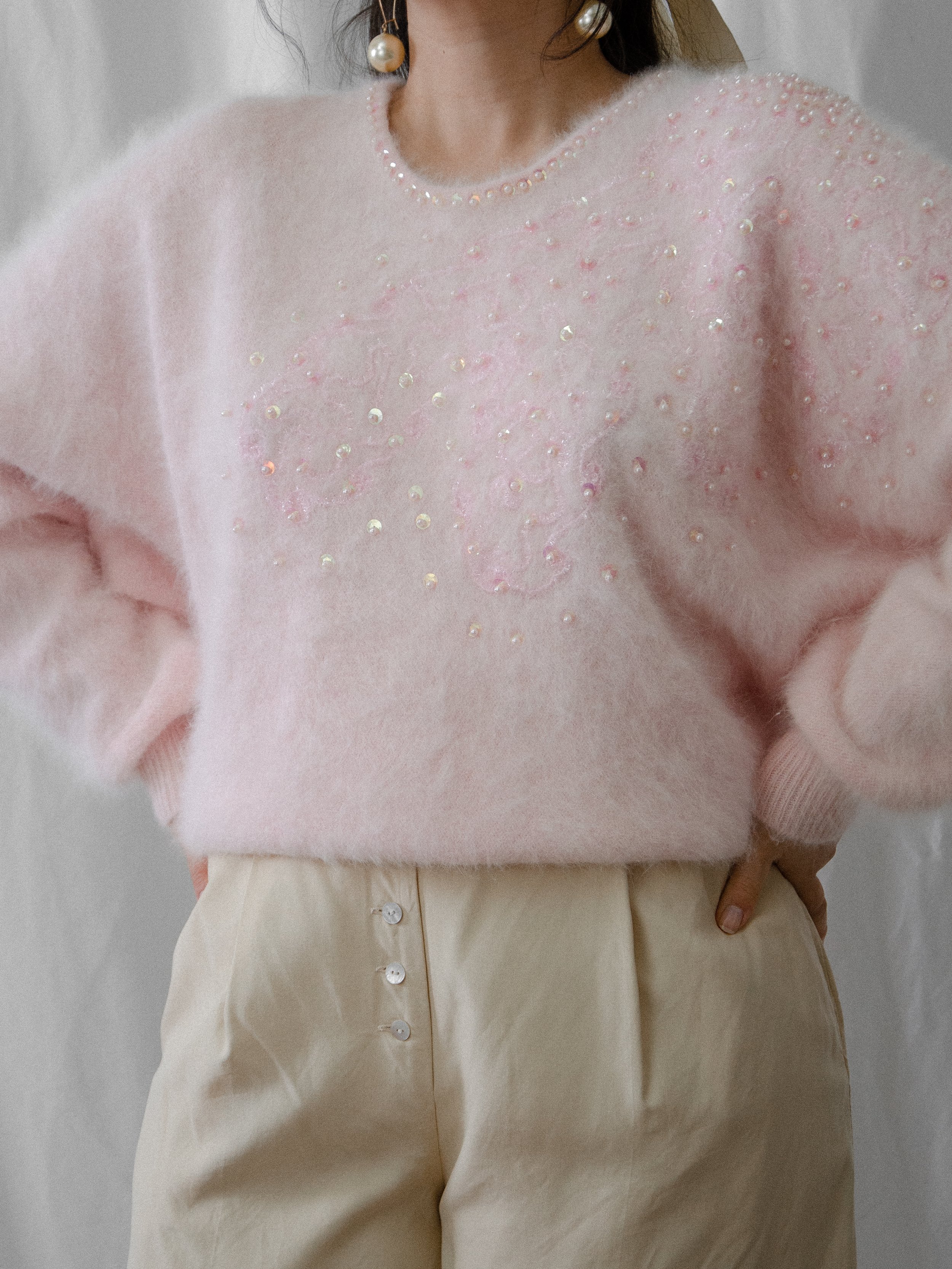 Front view of the 1980s pink angora sweater on a model, showing the sequin pattern on the chest.