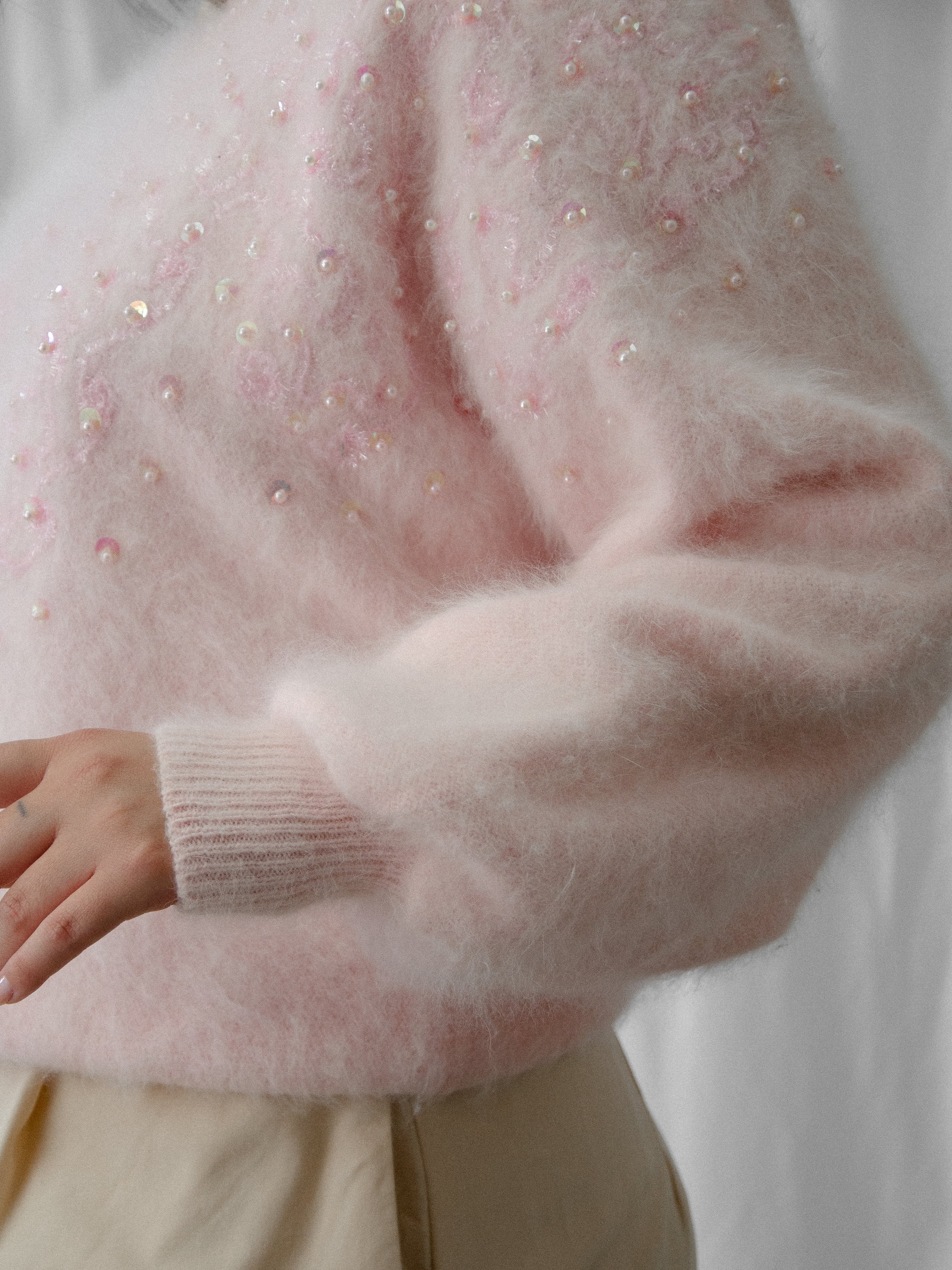 Detail of the 1980s pink angora sweater's dolman sleeve and ribbed cuff with sequins.