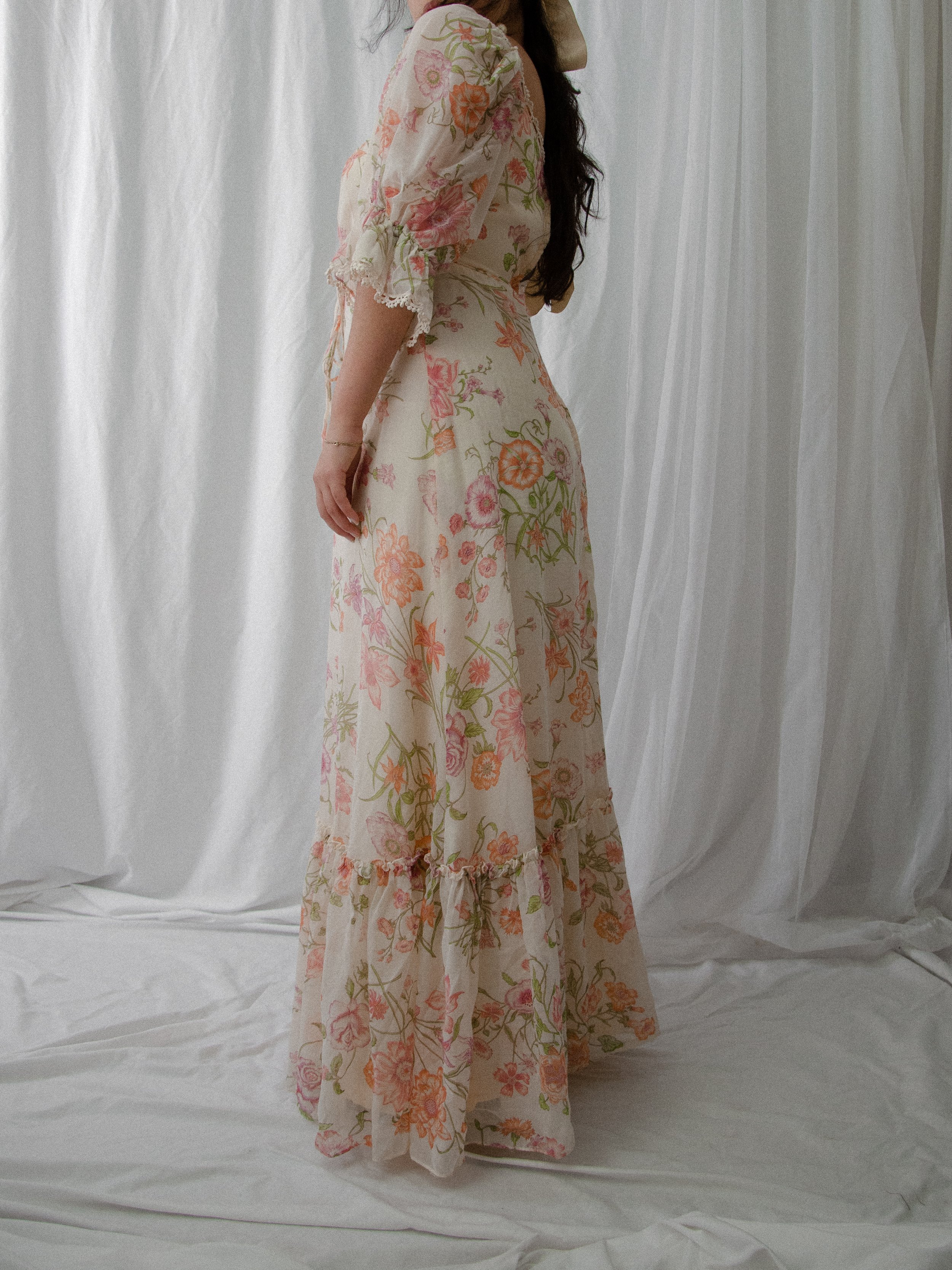 Side view of the 1970s cream floral maxi dress on a model, showing the long flowing skirt.