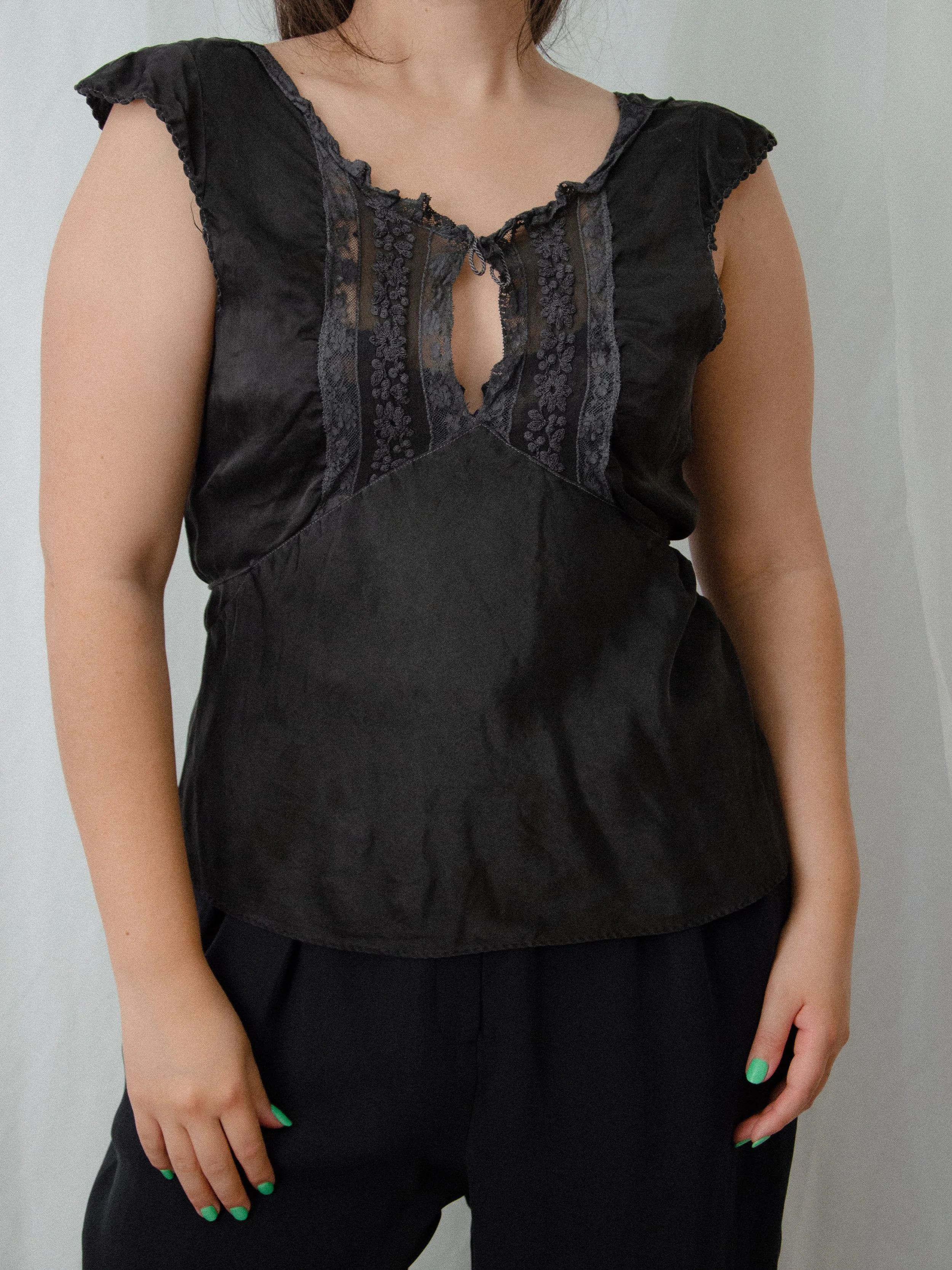 Front view of the 1930s charcoal silk top on a model, showing lace panels and keyhole neckline.