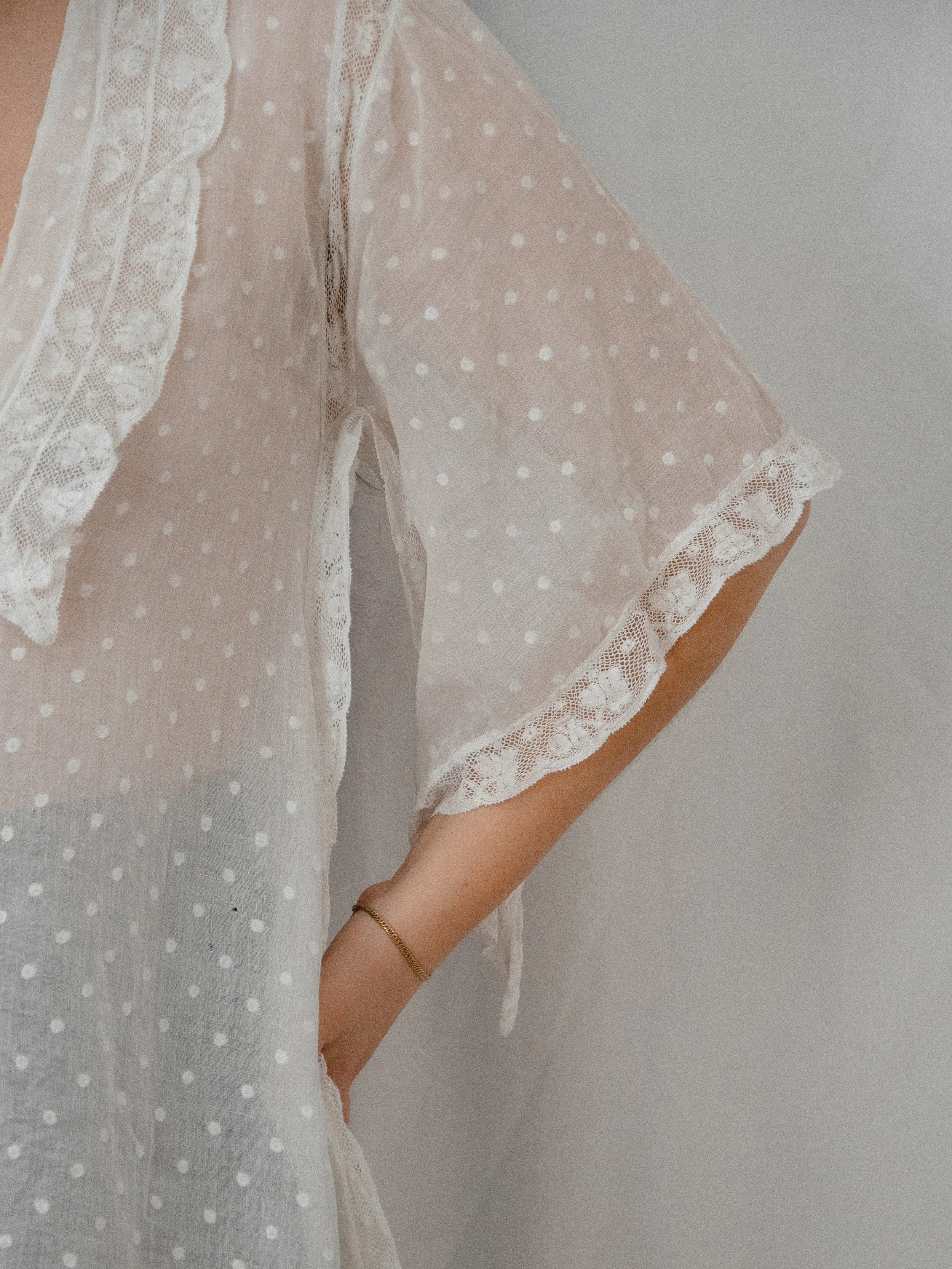 Close-up of the 1920s Swiss dot top's flared angel sleeve with lace trim.