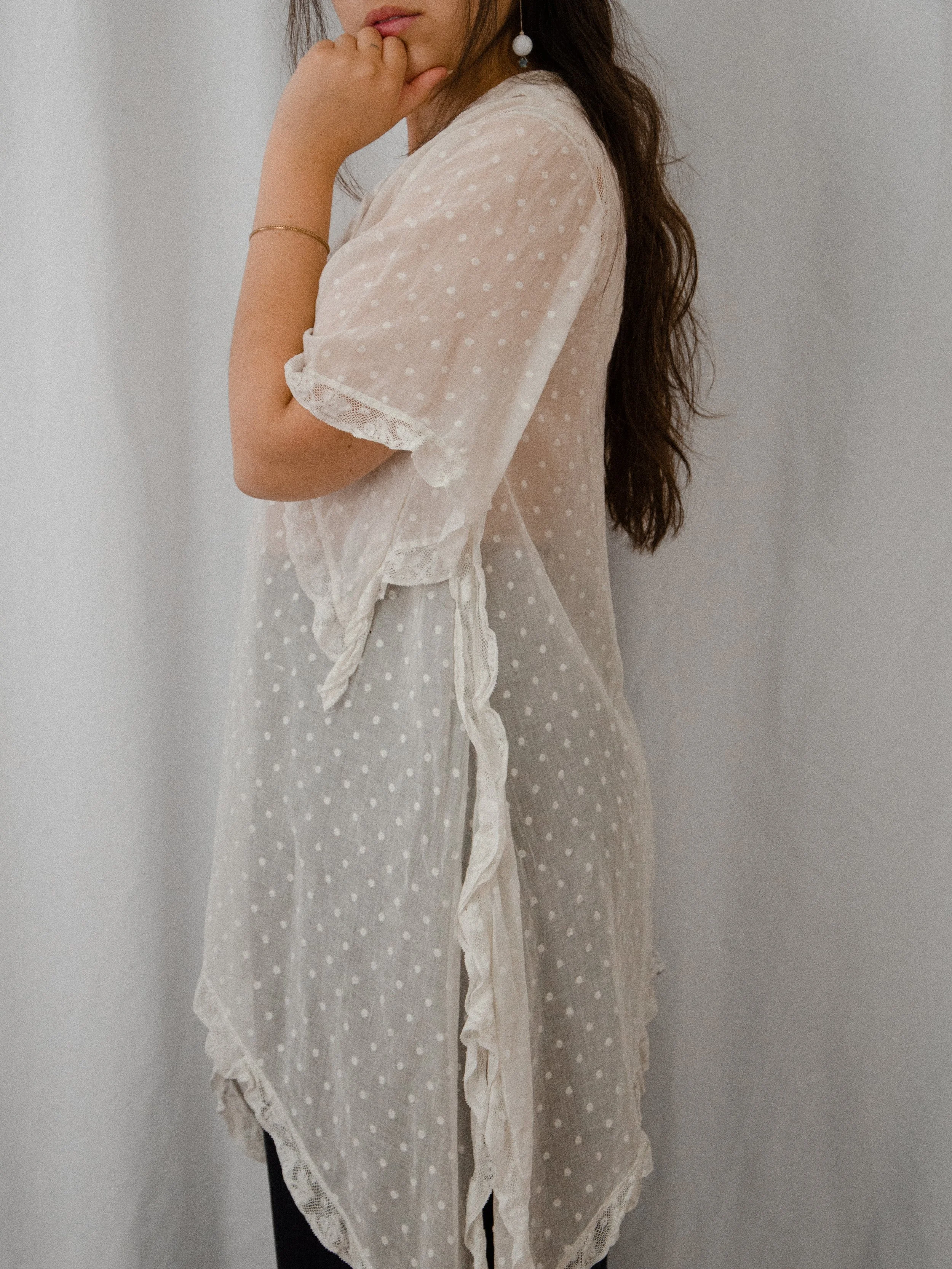 Side view of the 1920s sheer Swiss dot top on a model, showing the angel sleeve and pointed handkerchief hem.