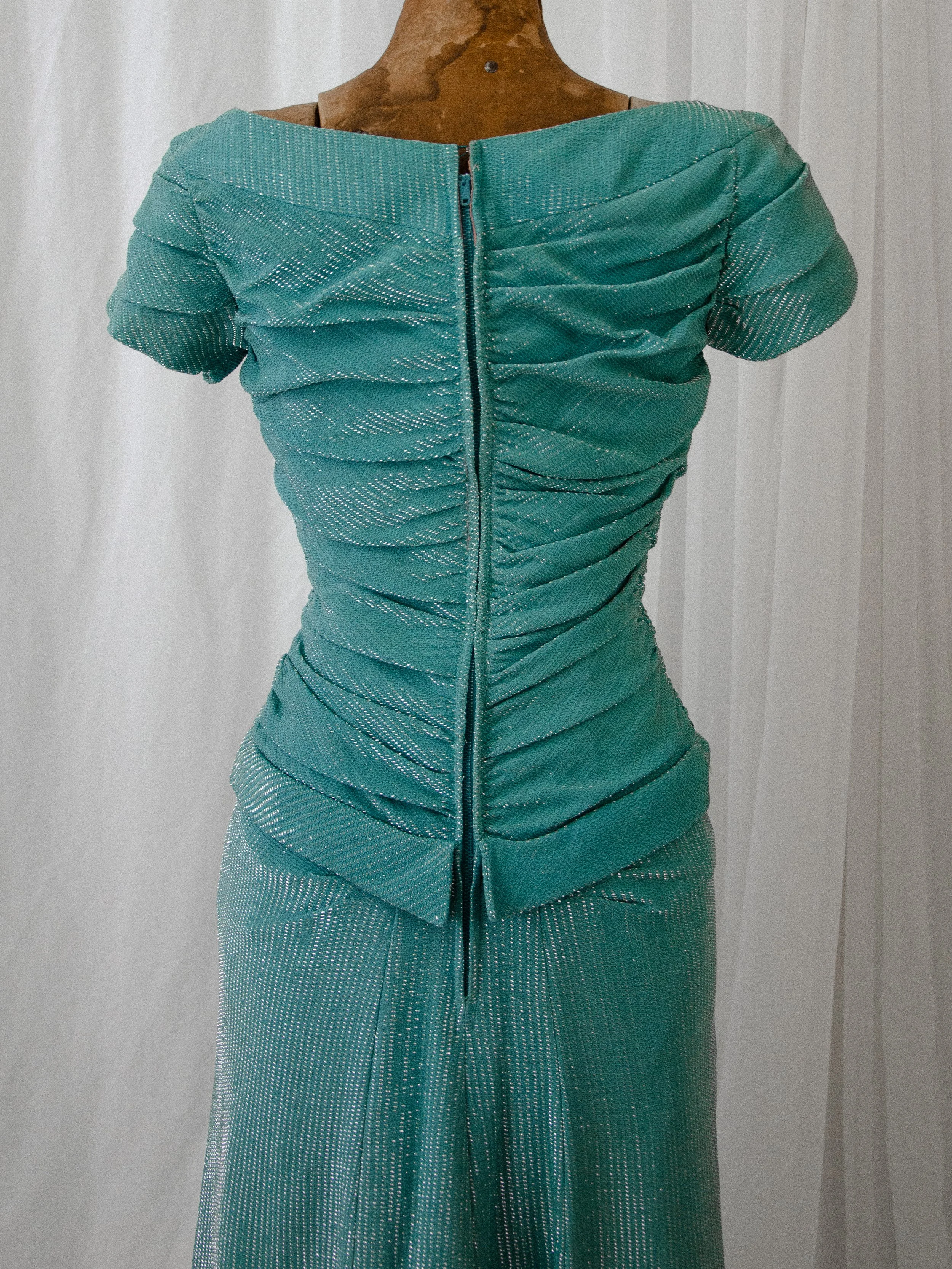 Close-up of the late 1940s turquoise lamé dress back, showing the ruched bodice and center zipper.