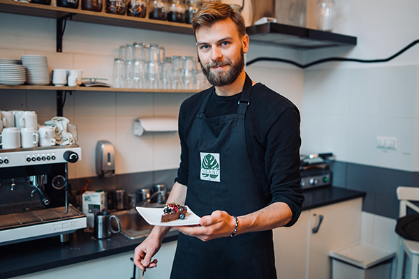 A cafe server delivering a slice of cake