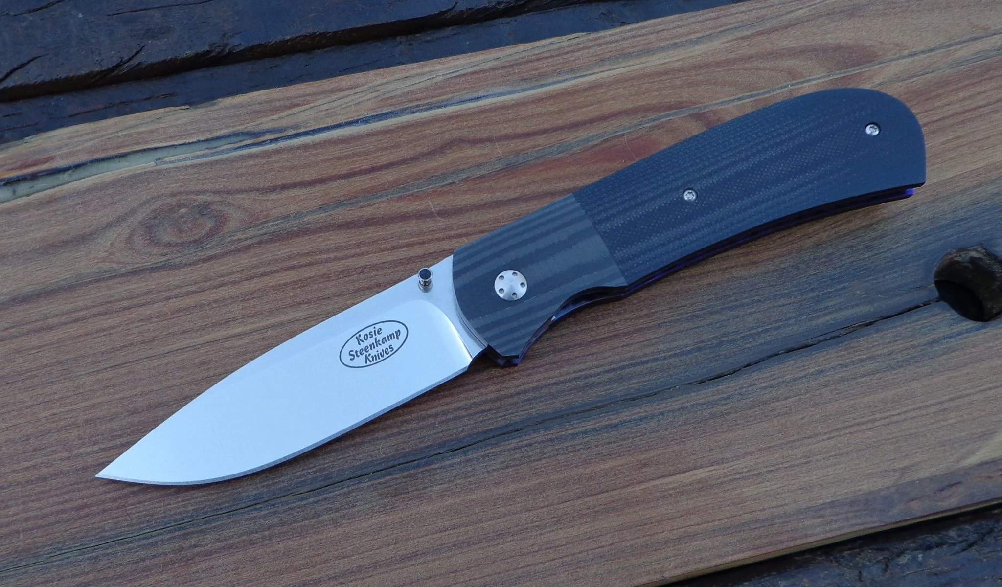 Knife: Sakson II. Blade: Böhler N690 Stainless Steel. Liners: Titanium, anodized blue. Handle scales: G10 and Carbon Fibre with anodized Titanium belt clip.