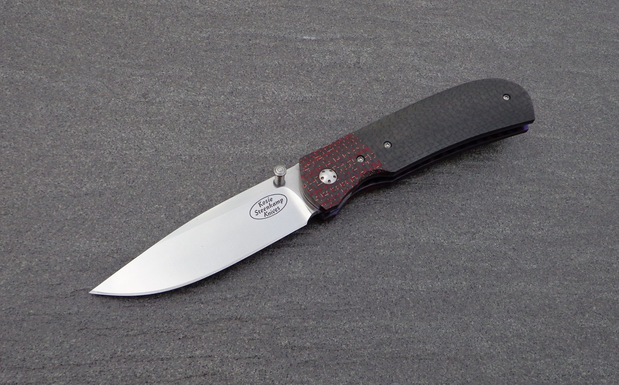Knife: Sakson II Liner Lock. Blade: Böhler N690 Stainless Steel. Liners: Titanium, anodized blue. Handle scales: Carbon Fiber and Lightning Strike Carbon Fiber with anodized Titanium belt clip.