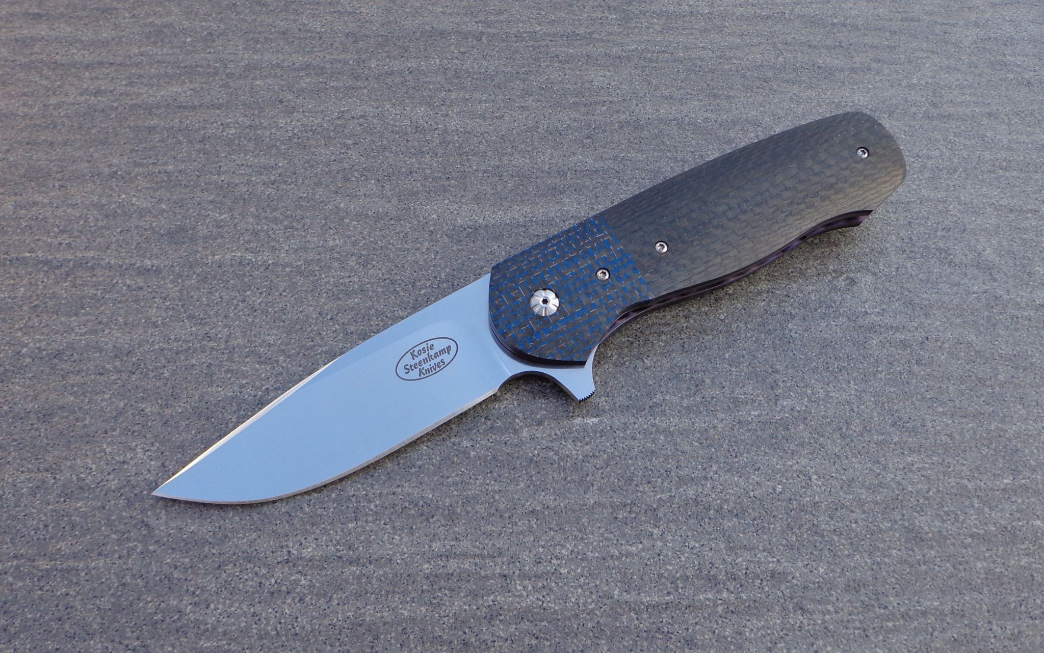 Knife: Vantage Flipper Liner Lock. Blade: Böhler N690 Stainless Steel. Liners: Titanium, anodized blue. Handle scales: Carbon Fiber with anodized Titanium belt clip. Bearing system.