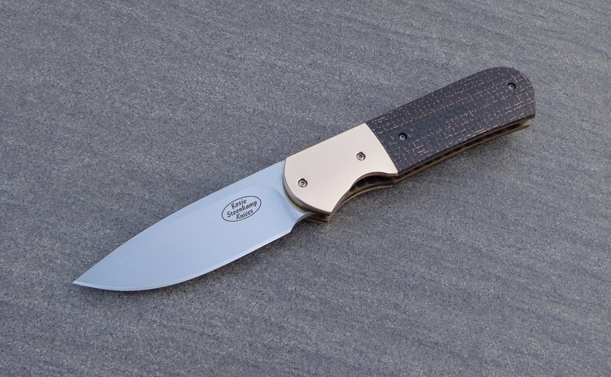 Knife: Samson Liner Lock. RWL-34 Stainless Steel Blade. Titanium liners. Bronze + LSCF handle. Titanium belt clip.